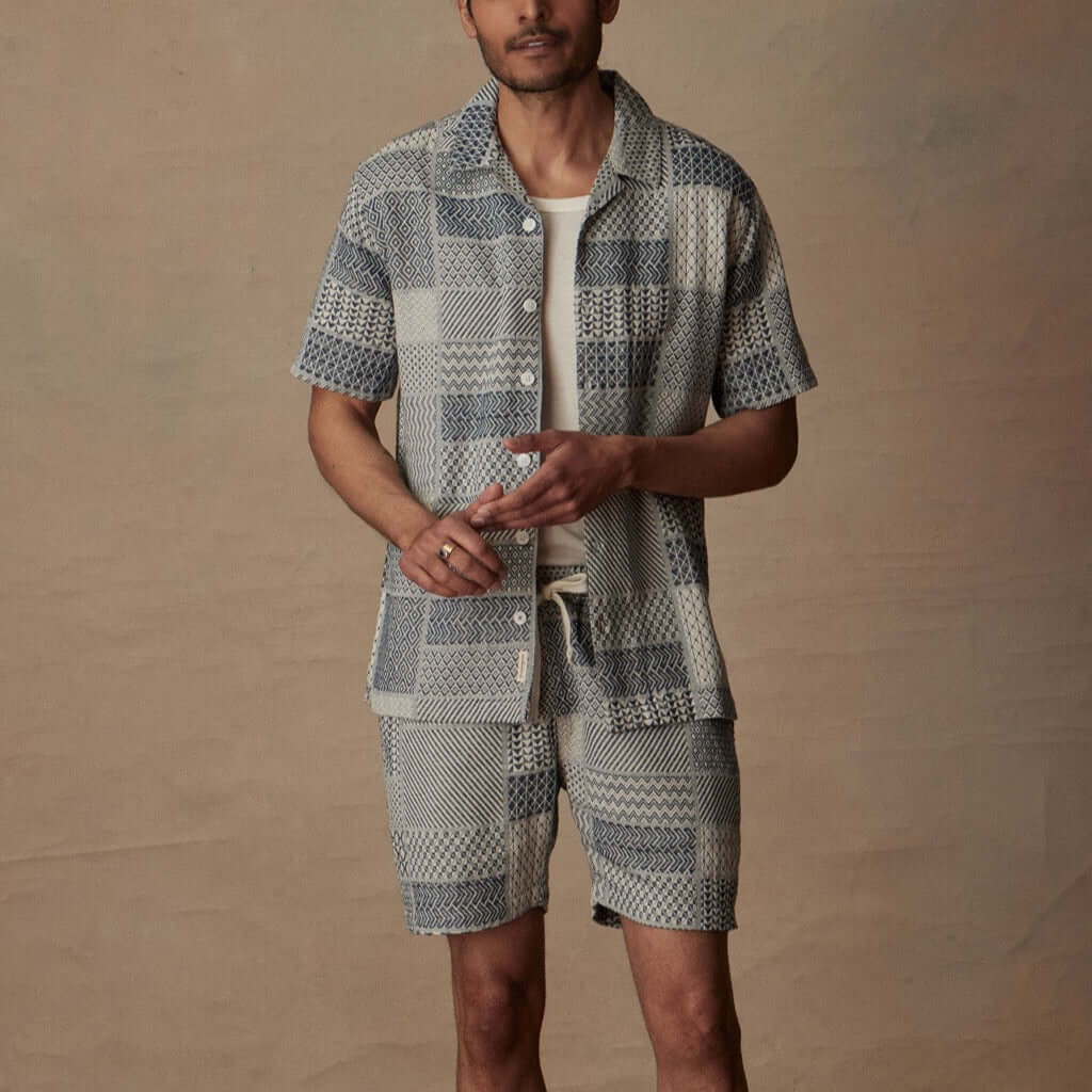 Man wearing a cream and navy jacquard short set, showcasing a relaxed style ideal for vacation.
