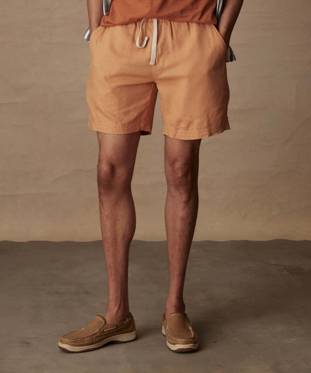 7" linen shorts in biscuit, featuring an elastic waist and adjustable drawcord for comfort.