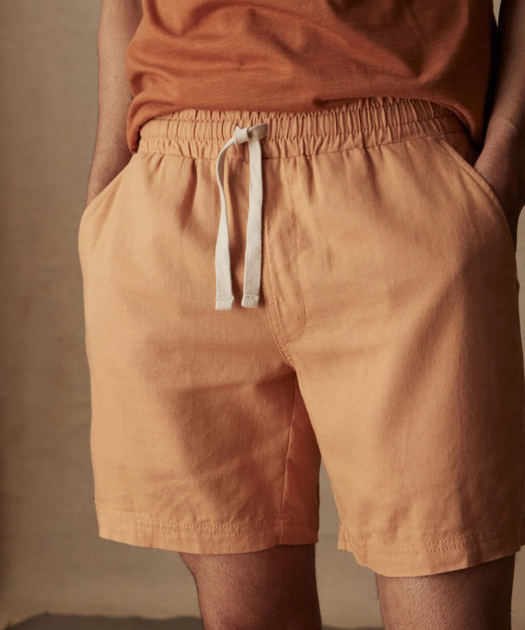7-inch linen shorts in biscuit color with elastic waist and adjustable drawstring, perfect for a breezy day.