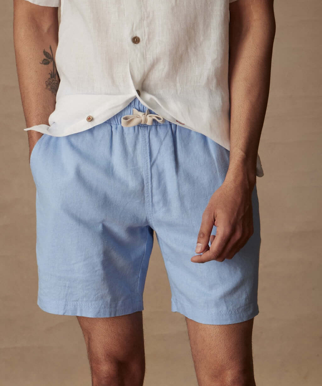 Men's 7" linen shorts in Fjord Blue with elastic waist and drawstring, perfect for casual summer outings.