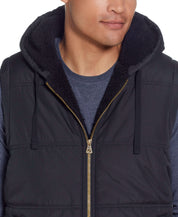 Sherpa Lined Hooded Puffer Vest In Black worn by a model, showcasing the drawcord hood and cozy sherpa lining.