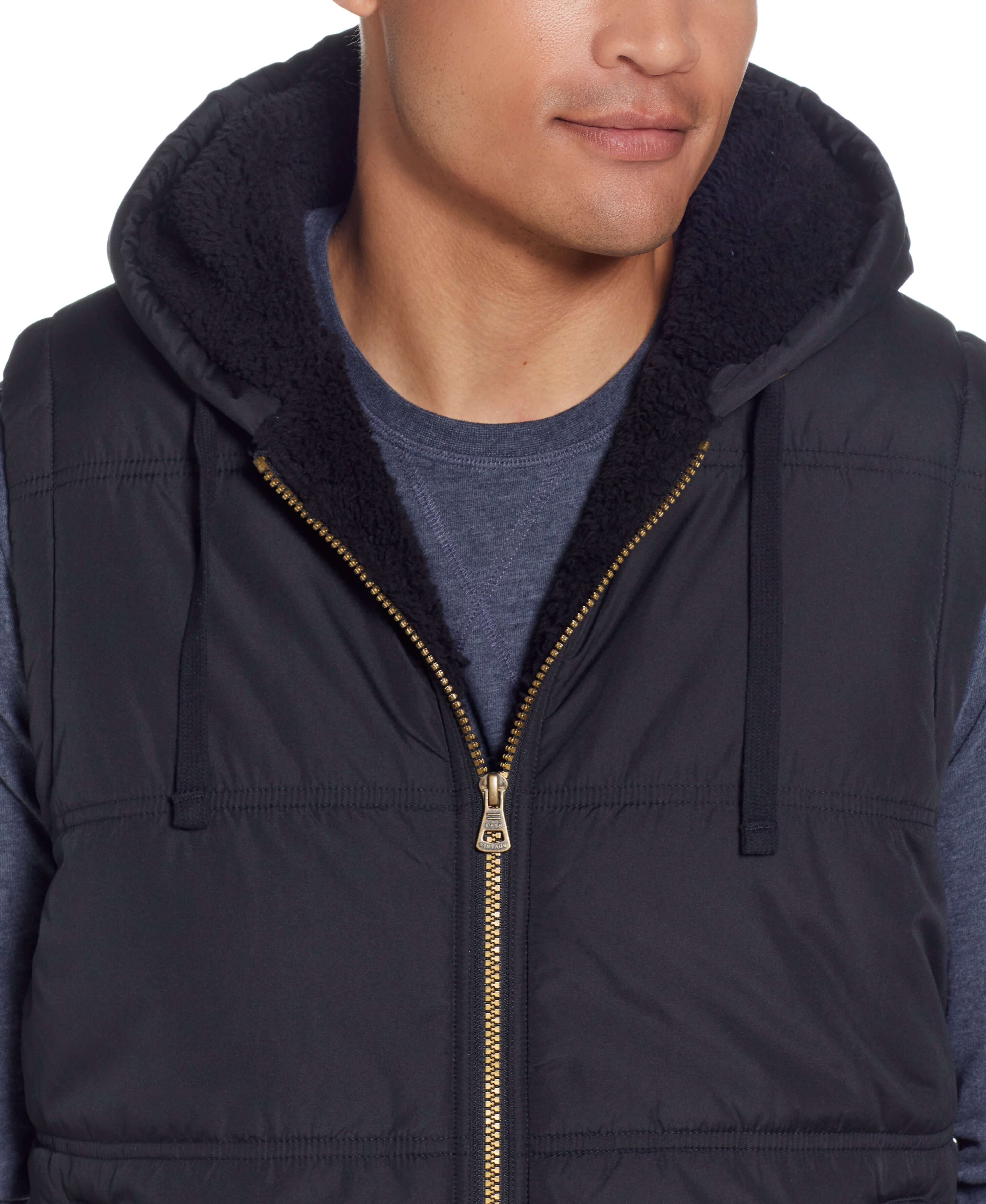 Sherpa Lined Hooded Puffer Vest In Black worn by a model, showcasing the drawcord hood and cozy sherpa lining.