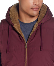 Close-up of a model wearing Sherpa Lined Hooded Puffer Vest In Port with a cozy sherpa lining and drawcord hood.