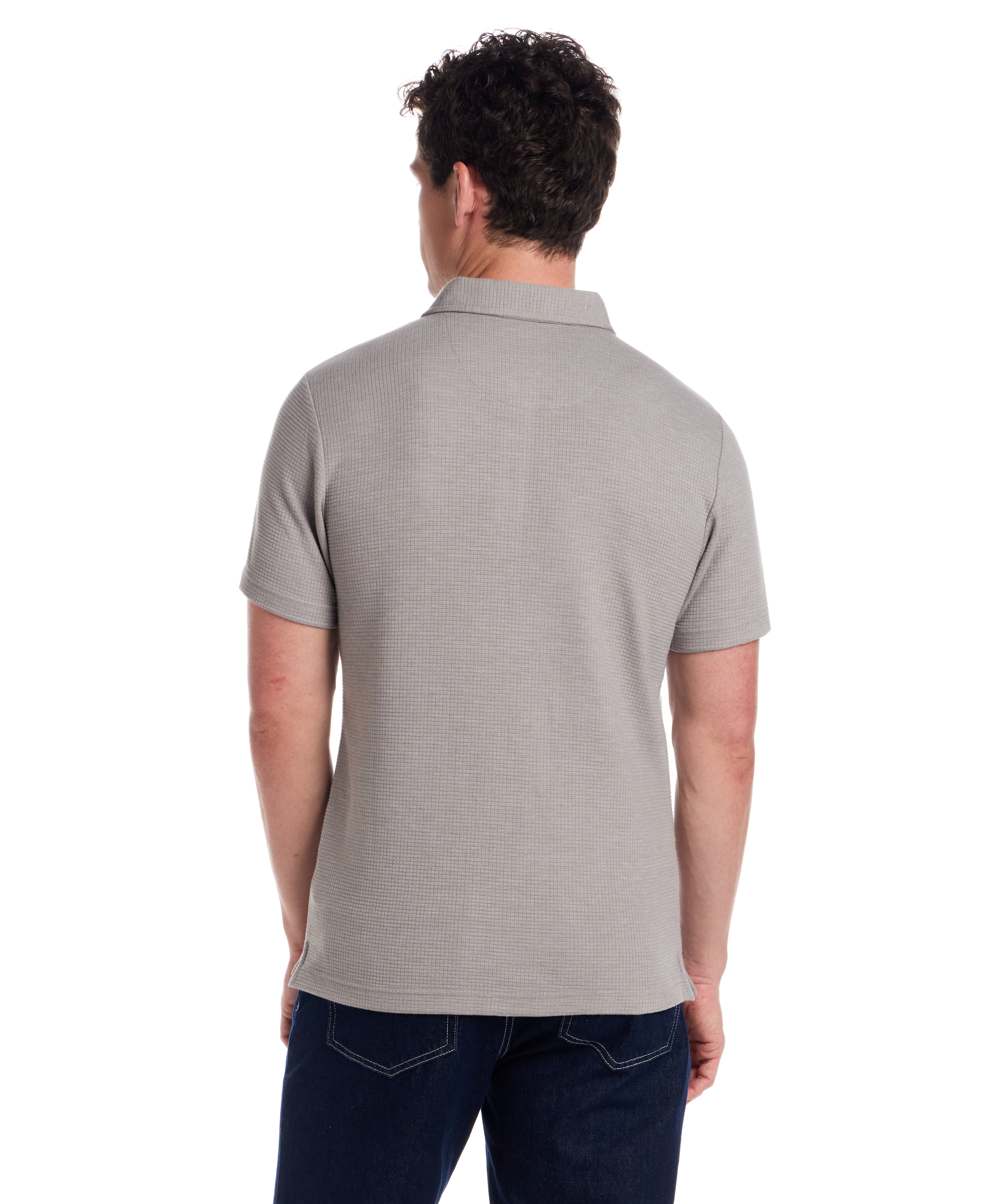 Back view of a man wearing a short sleeve stretch waffle polo in Ultimate Grey, showcasing the classic fit and clean collar.