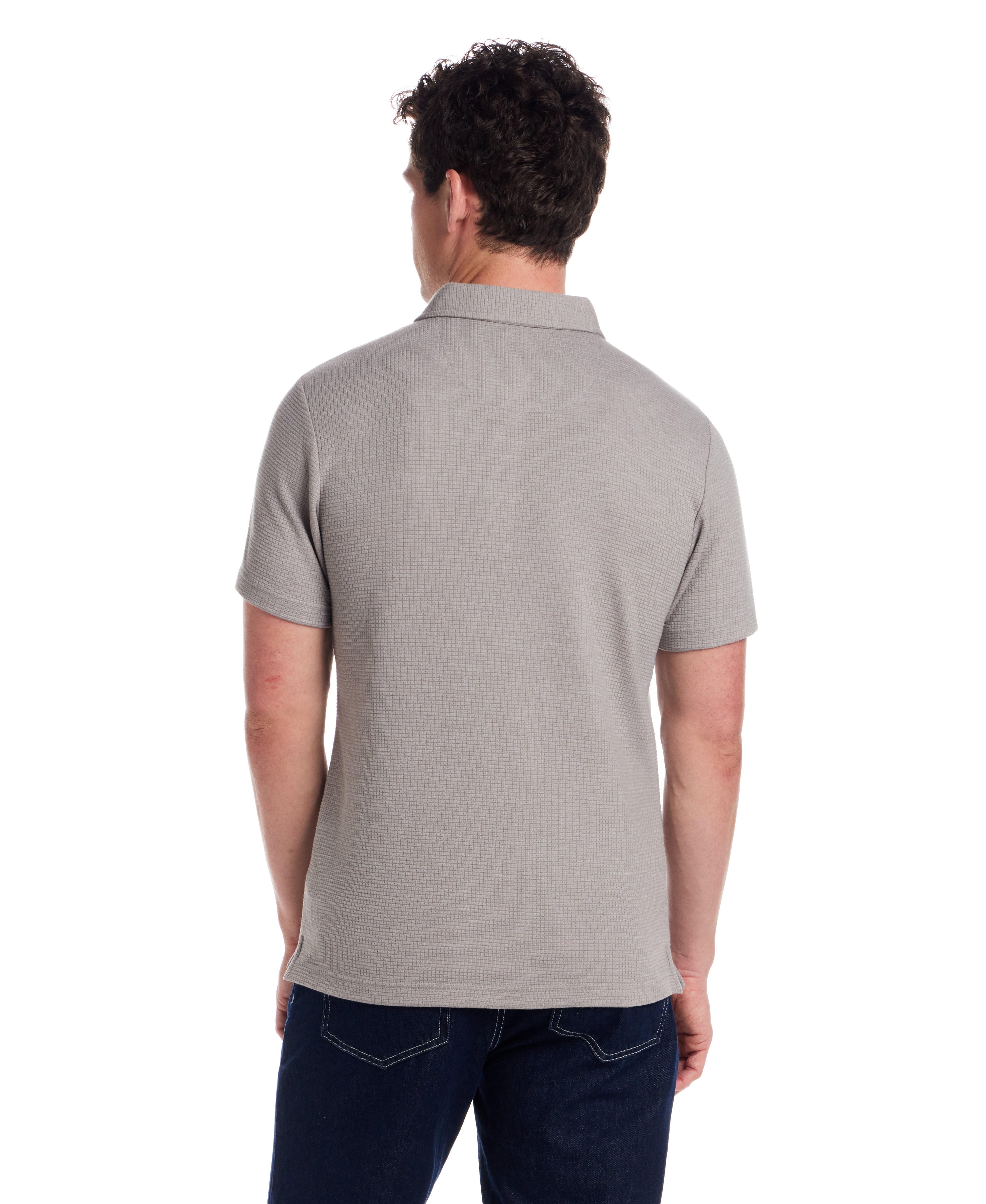 Back view of a man wearing a short sleeve stretch waffle polo in Ultimate Grey, showcasing the classic fit and clean collar.