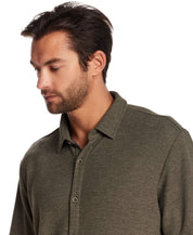 Man modeling a short sleeve waffle coat front tee in olive heather, showcasing the relaxed fit and button front detail.