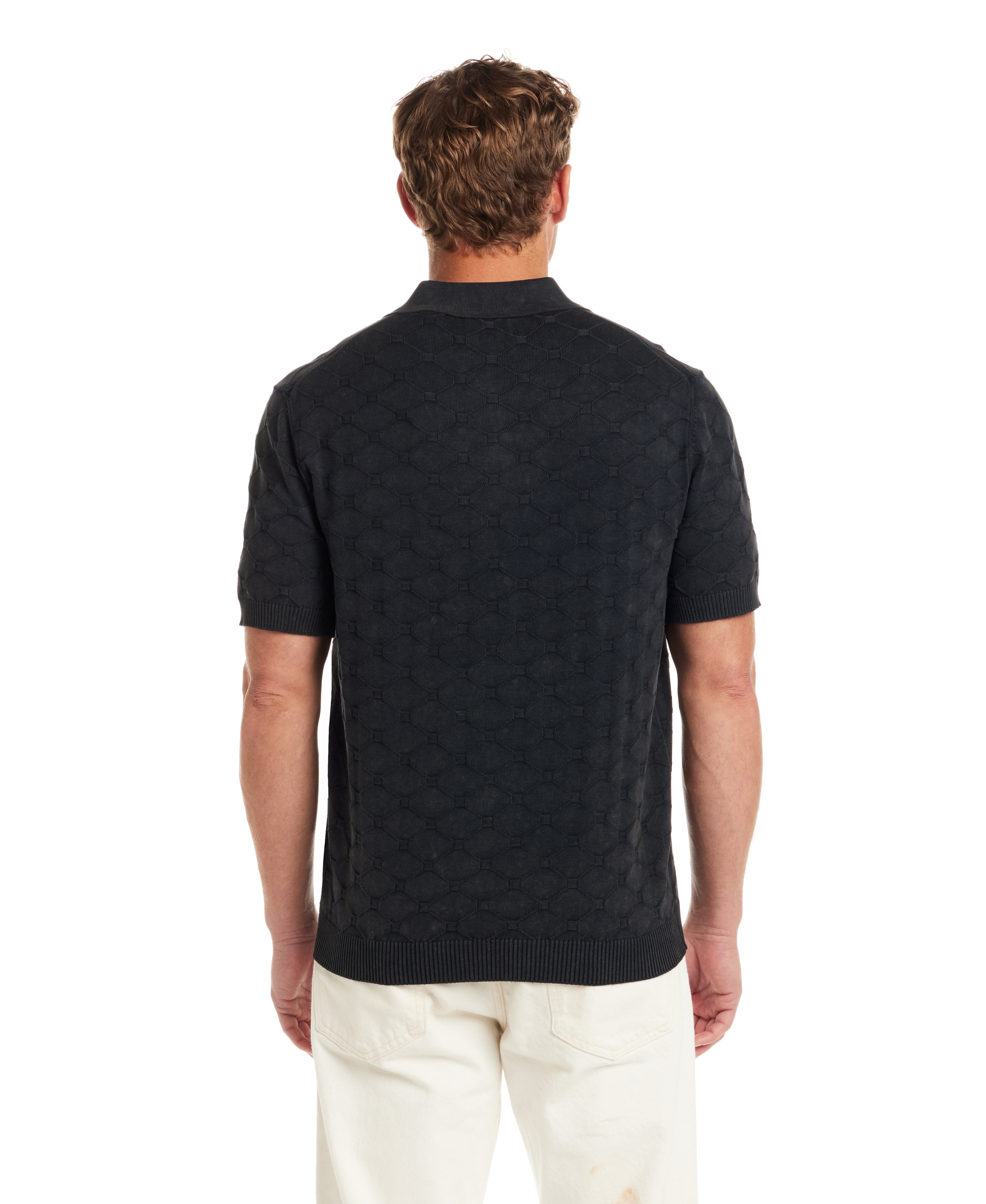 Rear view of a man wearing a Diamond Sweater Polo in Black featuring a textured pattern and tailored fit.