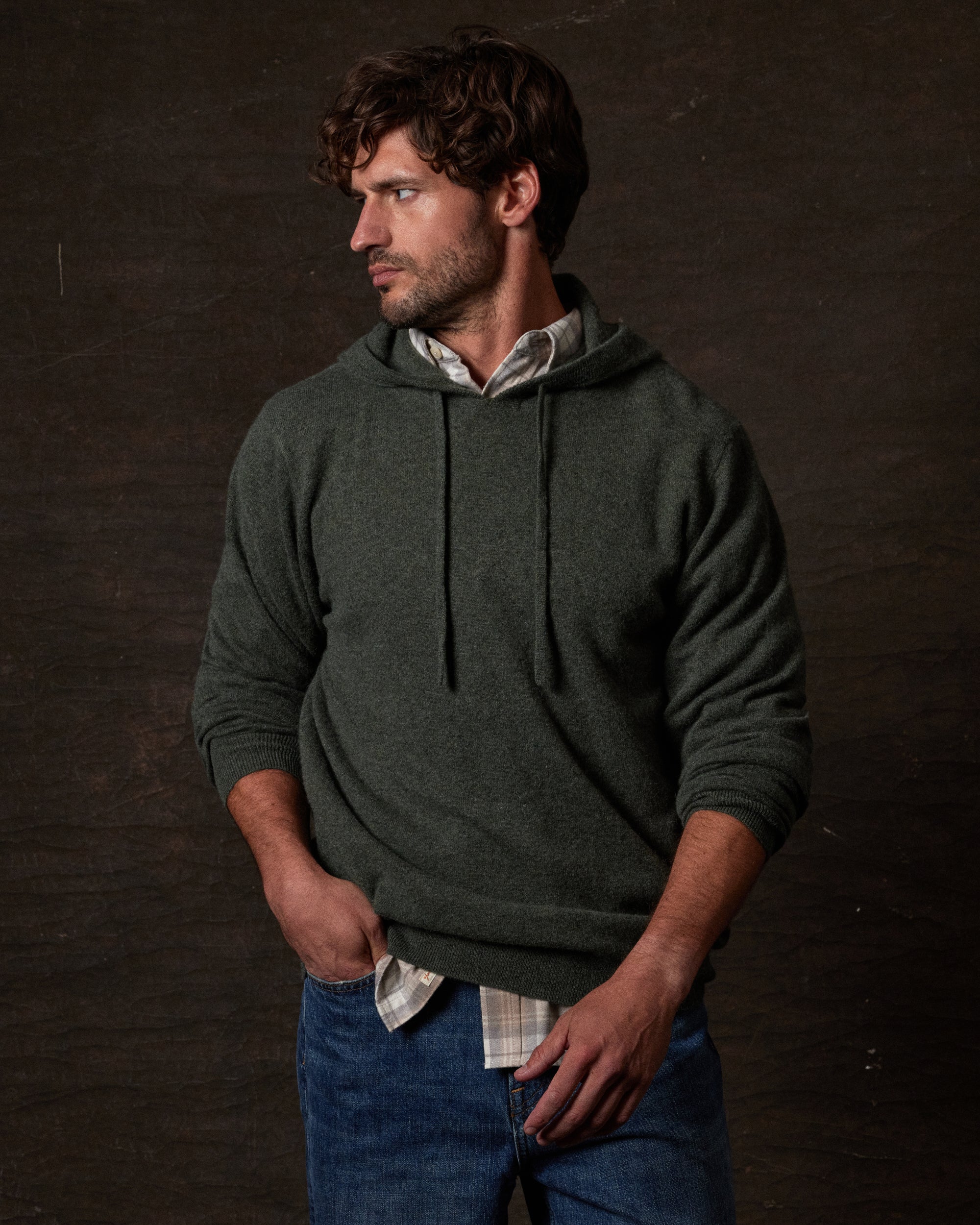 CASHMERE L/S SOLID HOODIE in FOREST GREEN worn by a man, showcasing its luxurious fabric and relaxed fit.