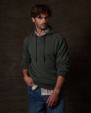CASHMERE L/S SOLID HOODIE in FOREST GREEN displayed on a model, showcasing its elegant design and cozy fit.
