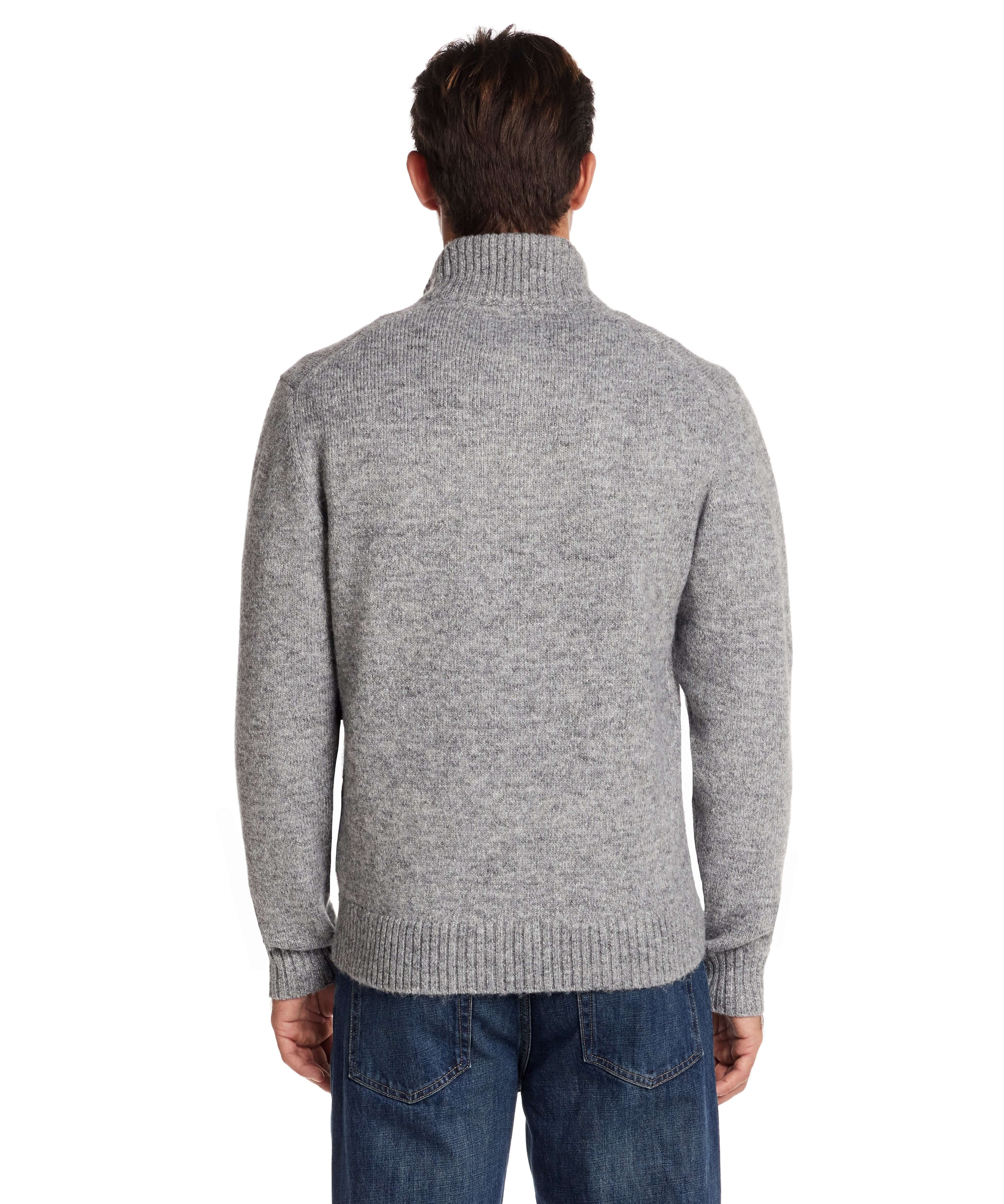 Back view of a man wearing a fuzzy grey quarter zip sweater with a mock neck and ribbed cuffs.