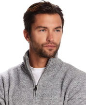 Man wearing a fuzzy quarter zip sweater in grey with a mock neck, showcasing a modern alpine layering style.
