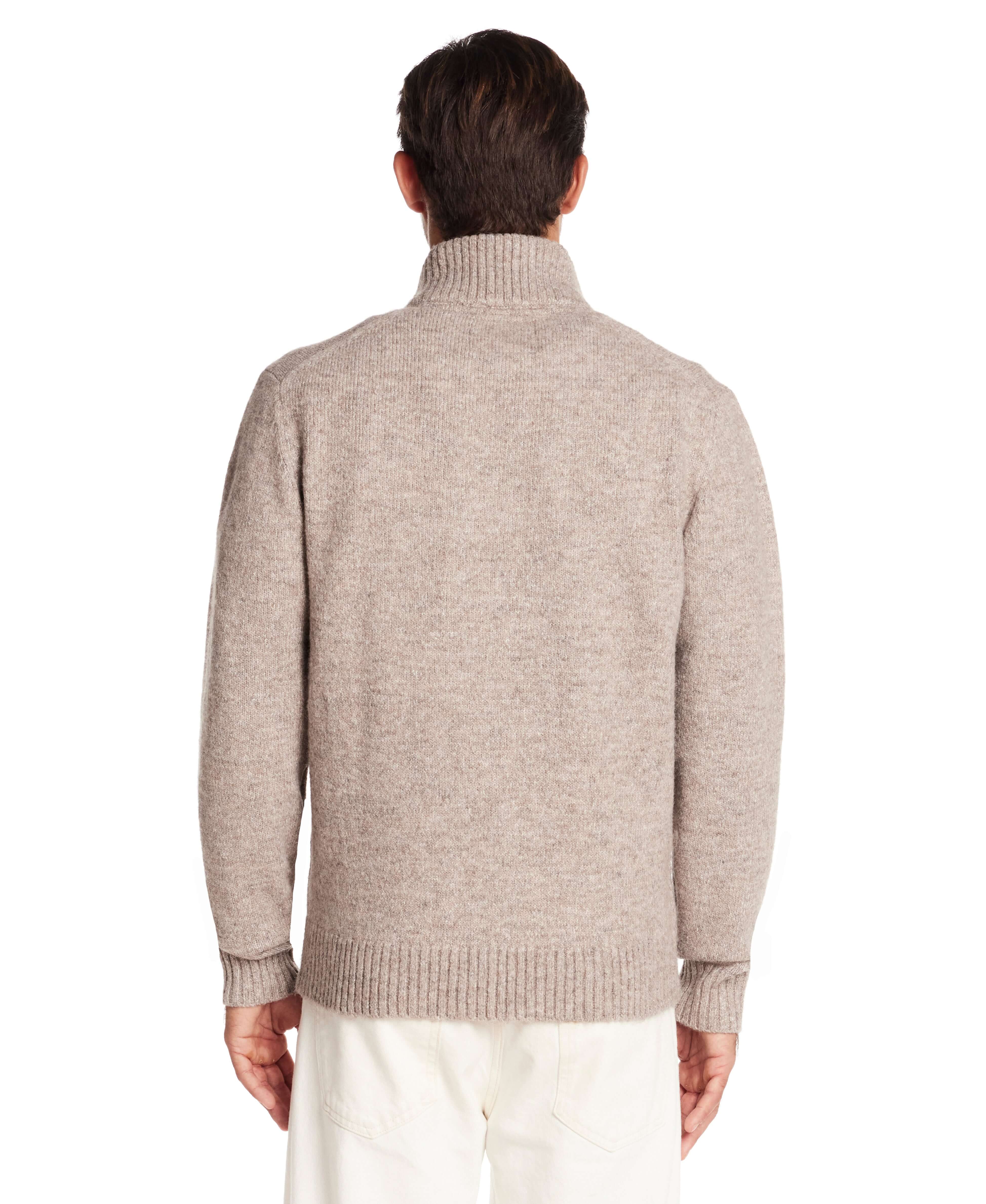 Back view of a man wearing a taupe fuzzy quarter zip sweater with a mock neck and ribbed hem.