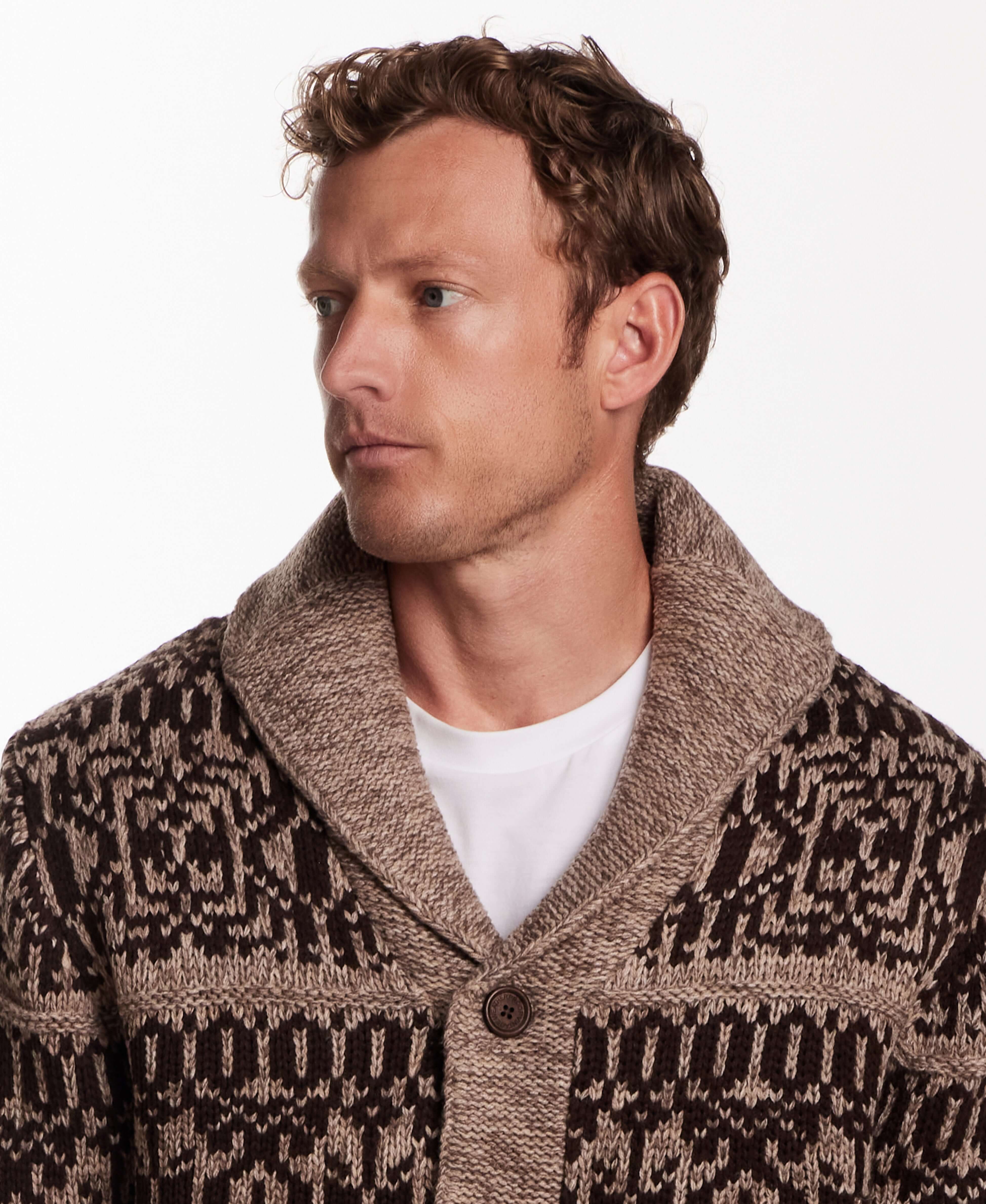 Man wearing a shawl collar sweater jacket in mocha with a textured knit pattern, featuring a button closure.