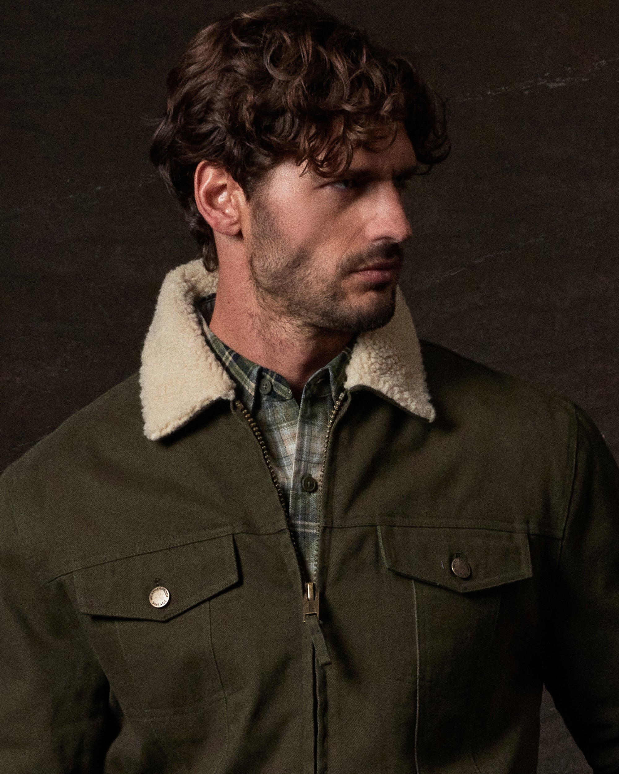 Sherpa Lined Canvas Twill Trucker in Dark Olive worn by a model showcasing the sherpa collar and button-flap pockets.