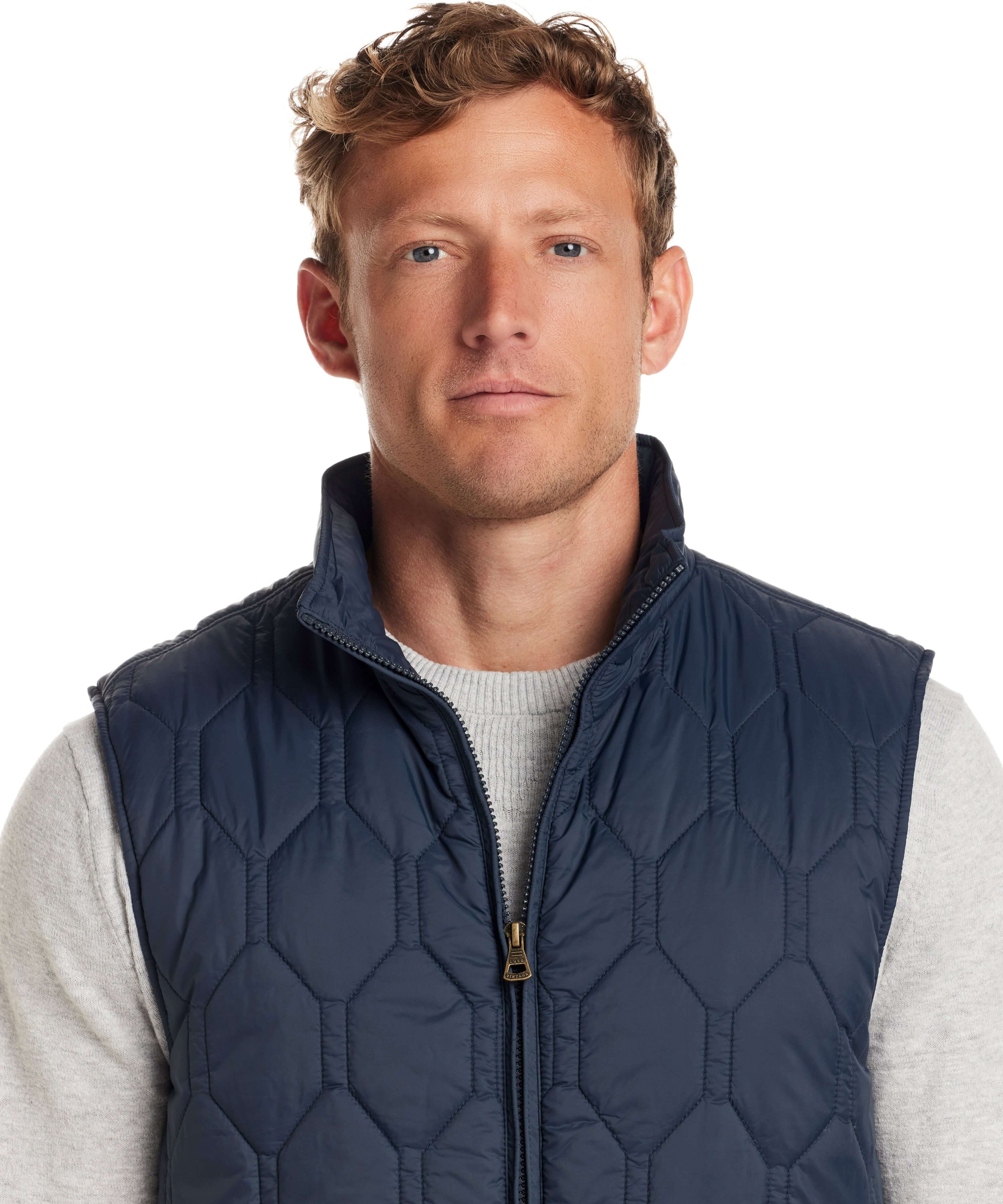 Man wearing a Hexagon Quilted Lightweight Vest in Slate Blue, featuring a front zipper and mock neck.