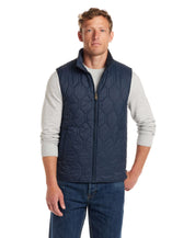 Hexagon quilted lightweight vest in slate blue, featuring front zipper, mock-neck, and side pockets, worn by male model.