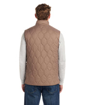 Back view of a man wearing a Hexagon Quilted Lightweight Vest in Mountain Trail, showcasing its unique hexagon pattern and mock-neck design.