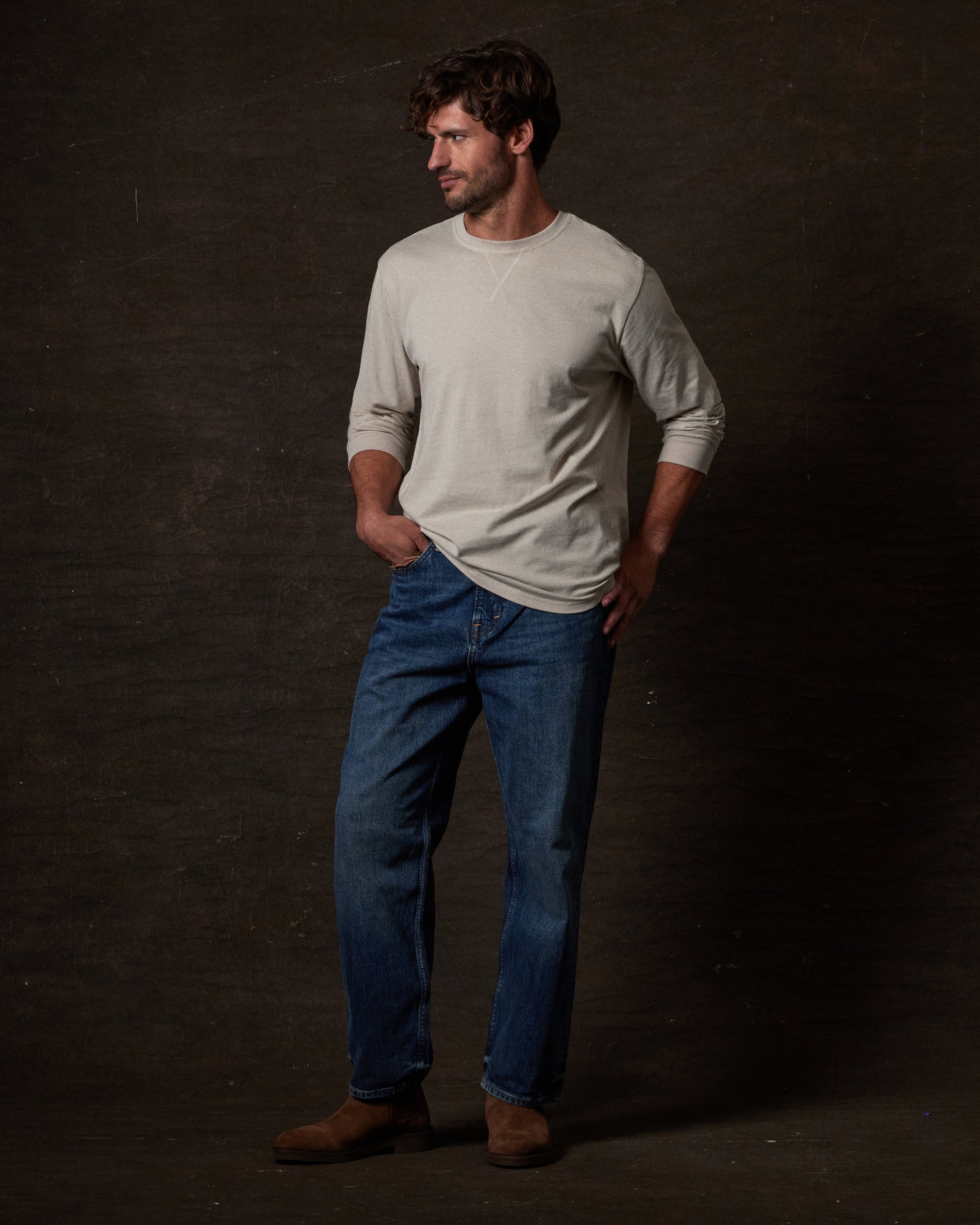 Long Sleeve Brushed Jersey Crew in NATURAL worn by a model with jeans and boots on a textured background.