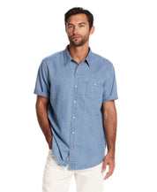 Model wearing a relaxed fit short sleeve stripe denim shirt in serenity blue with classic collar and chest pocket.