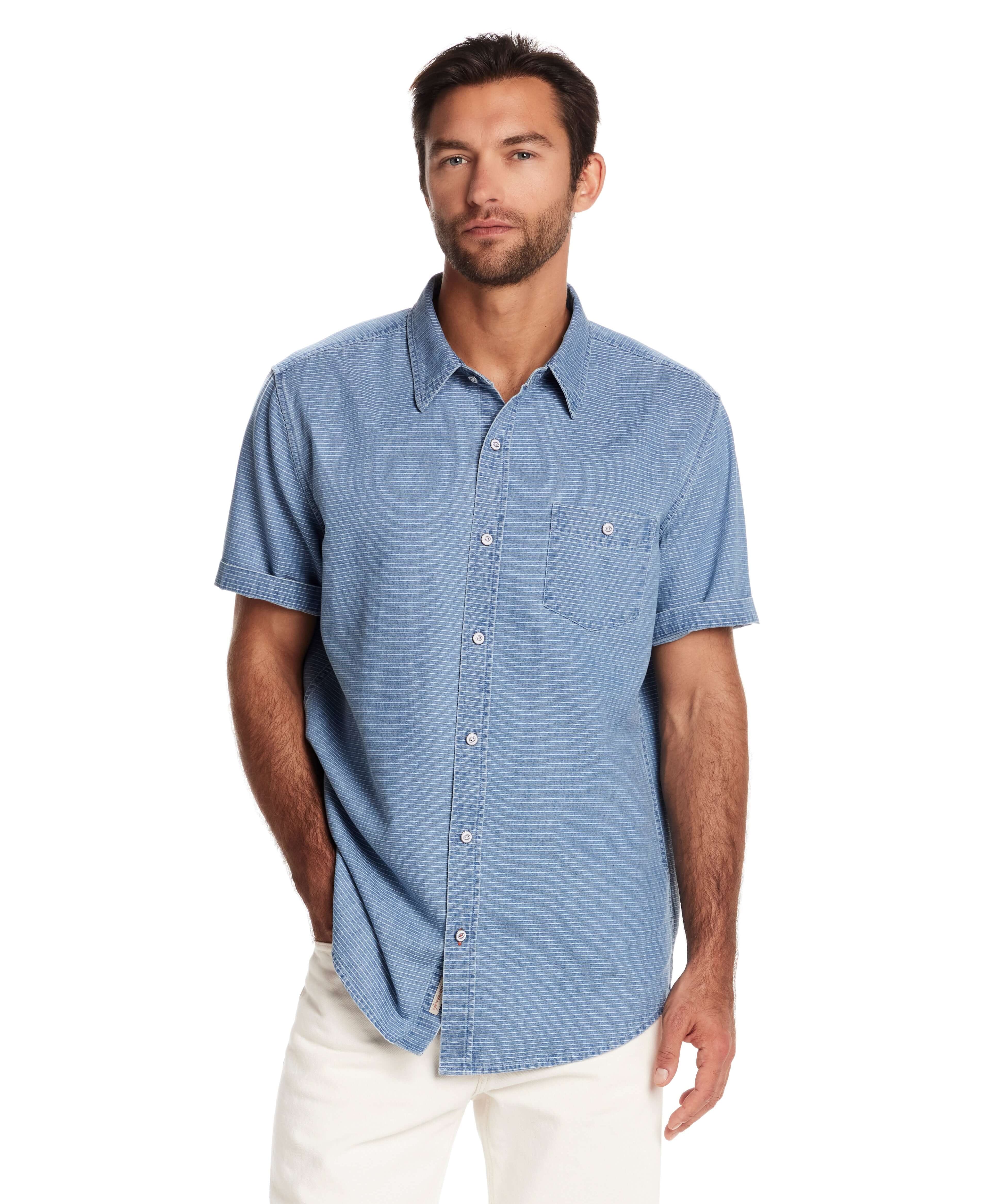 Model wearing a relaxed fit short sleeve stripe denim shirt in serenity blue with classic collar and chest pocket.