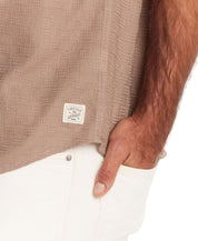 Close-up of short sleeve textured dobby shirt in Mountain Trail with vintage tag, highlighting checkered texture and relaxed fit.