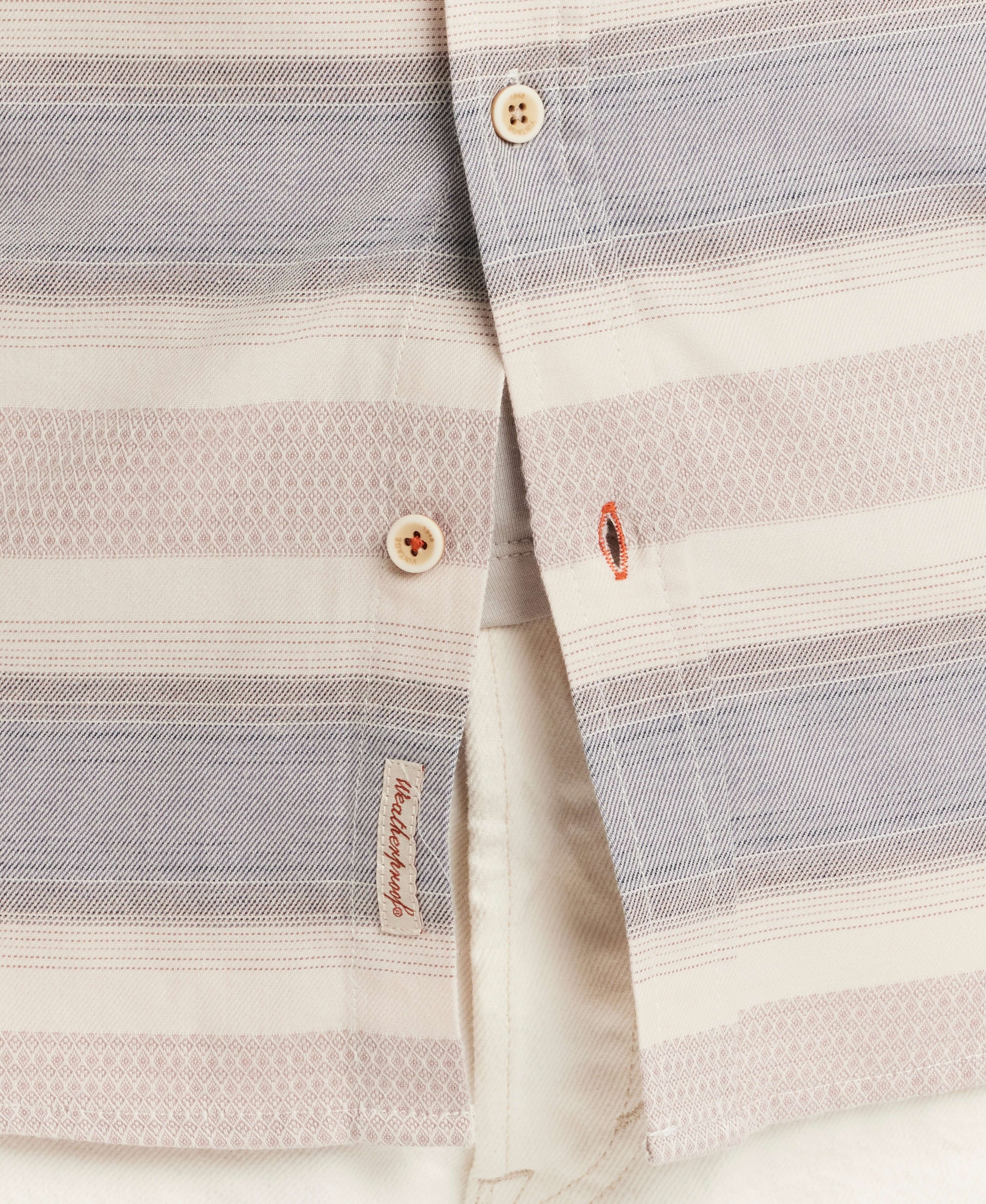 Close-up of a lightweight short-sleeve shirt showcasing a refined dobby weave and button details in soft hues.