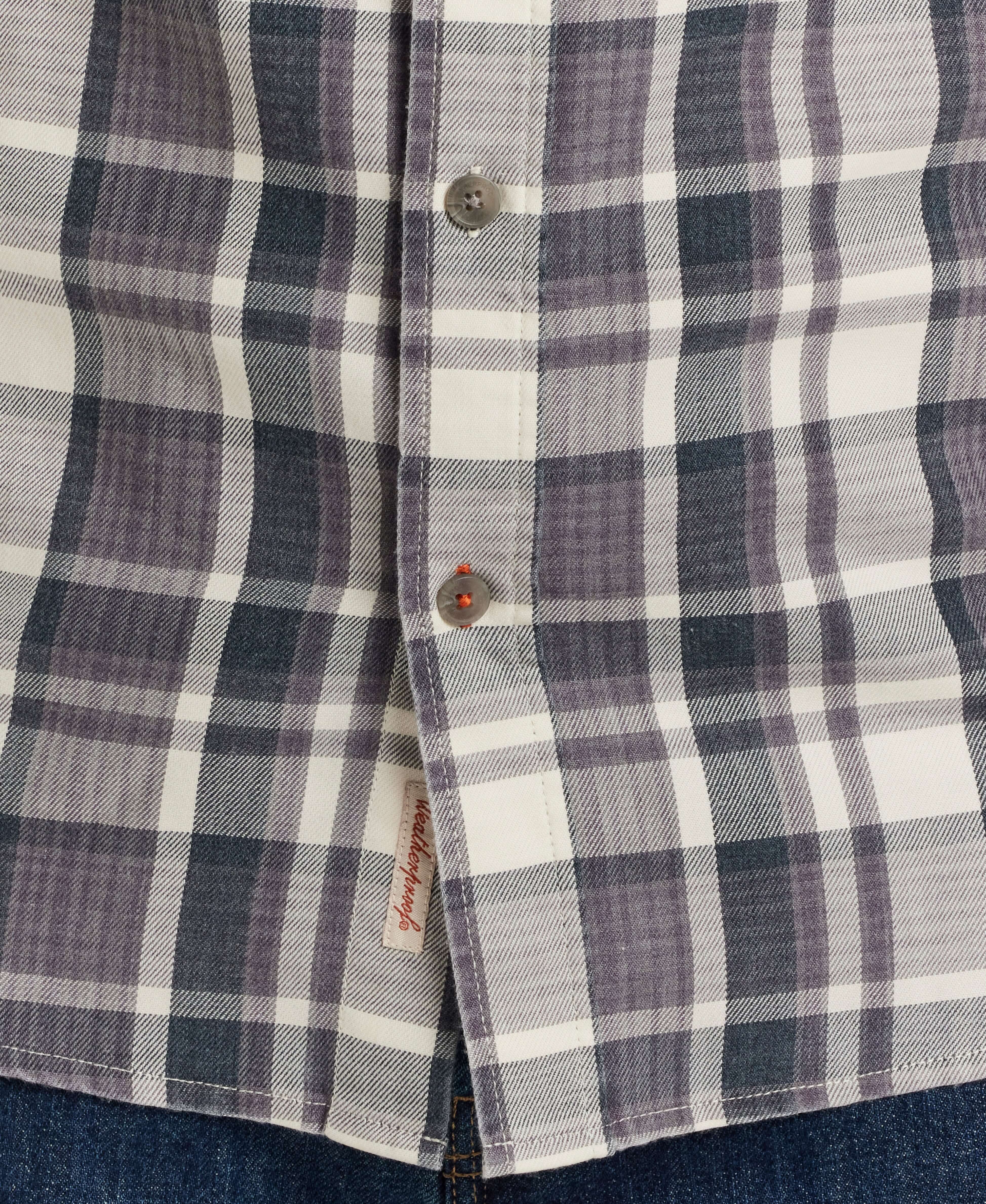 Close-up of a buttoned placket on a long sleeve burnout flannel shirt in Nine Iron plaid pattern.