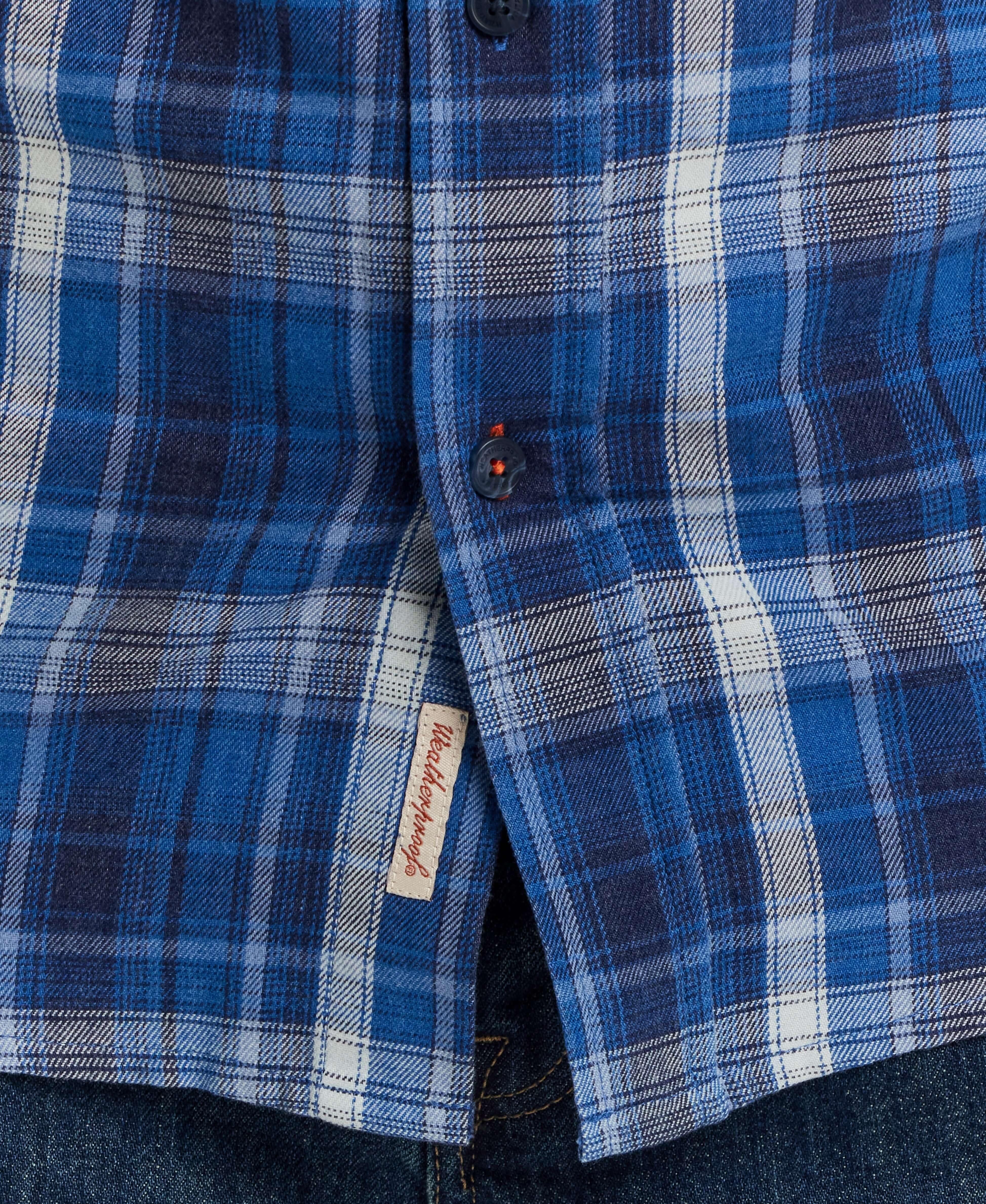 Close-up of Long Sleeve Burnout Flannel shirt in Strong Blue, featuring a classic plaid pattern and button details.