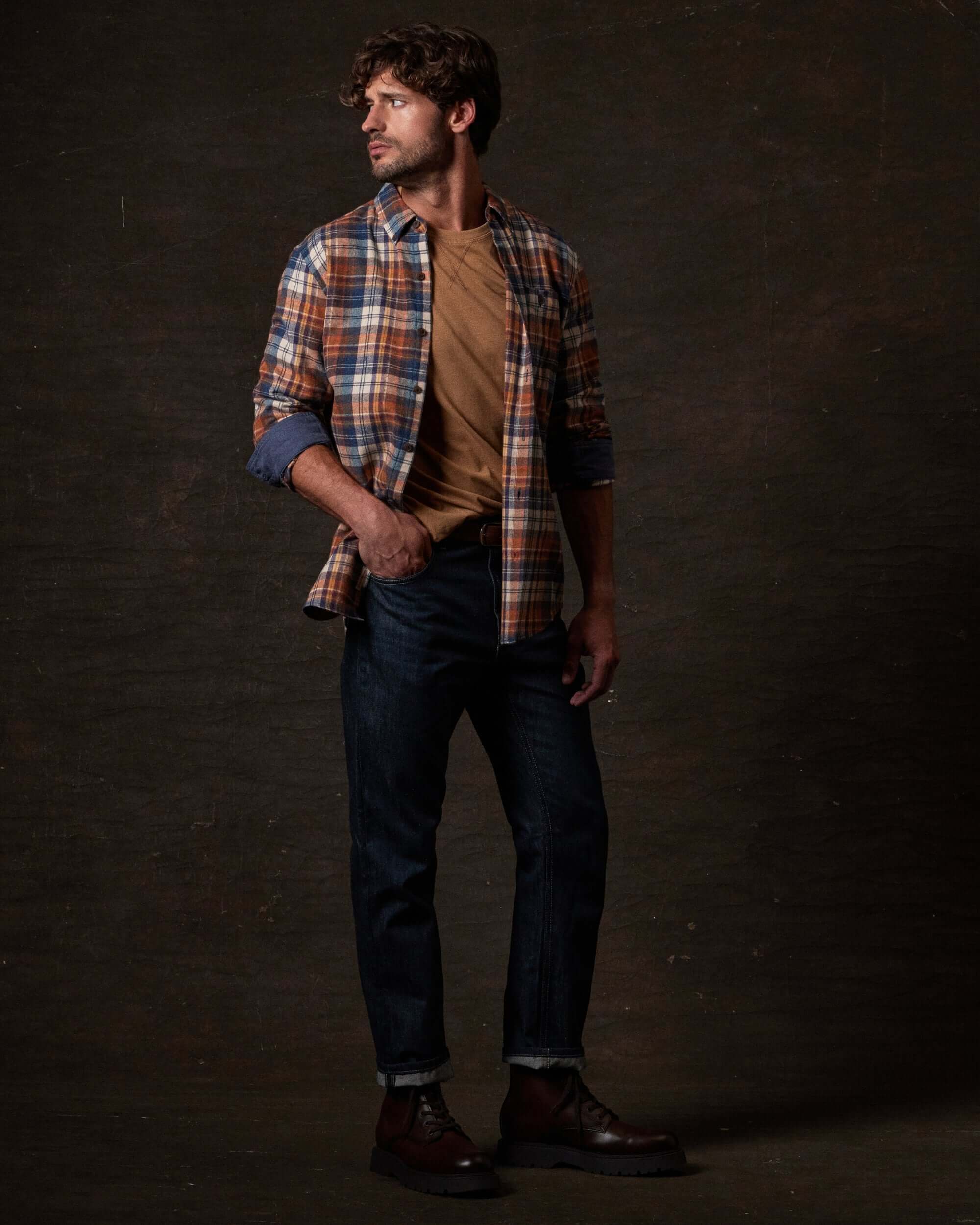 Long Sleeve Brushed Flannel in Umber worn by a model with jeans and a t-shirt, showcasing its rugged design.