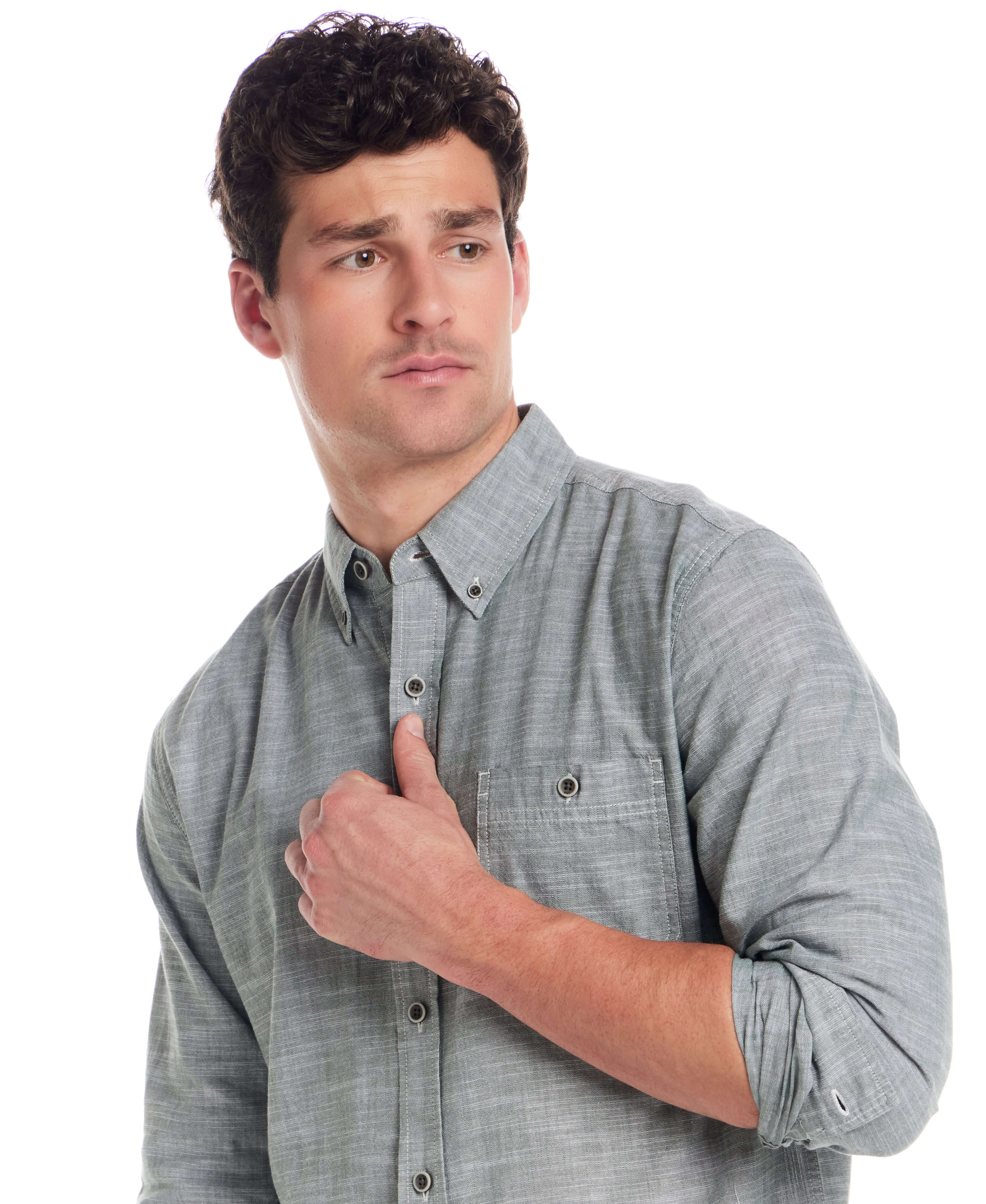 Model wearing a long sleeve chambray button-down shirt in duck green with a button-down collar and chest pocket.