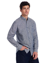 Model wearing a Long Sleeve Chambray Button-Down shirt in Insignia Blue, featuring a button-down collar and chest pocket.