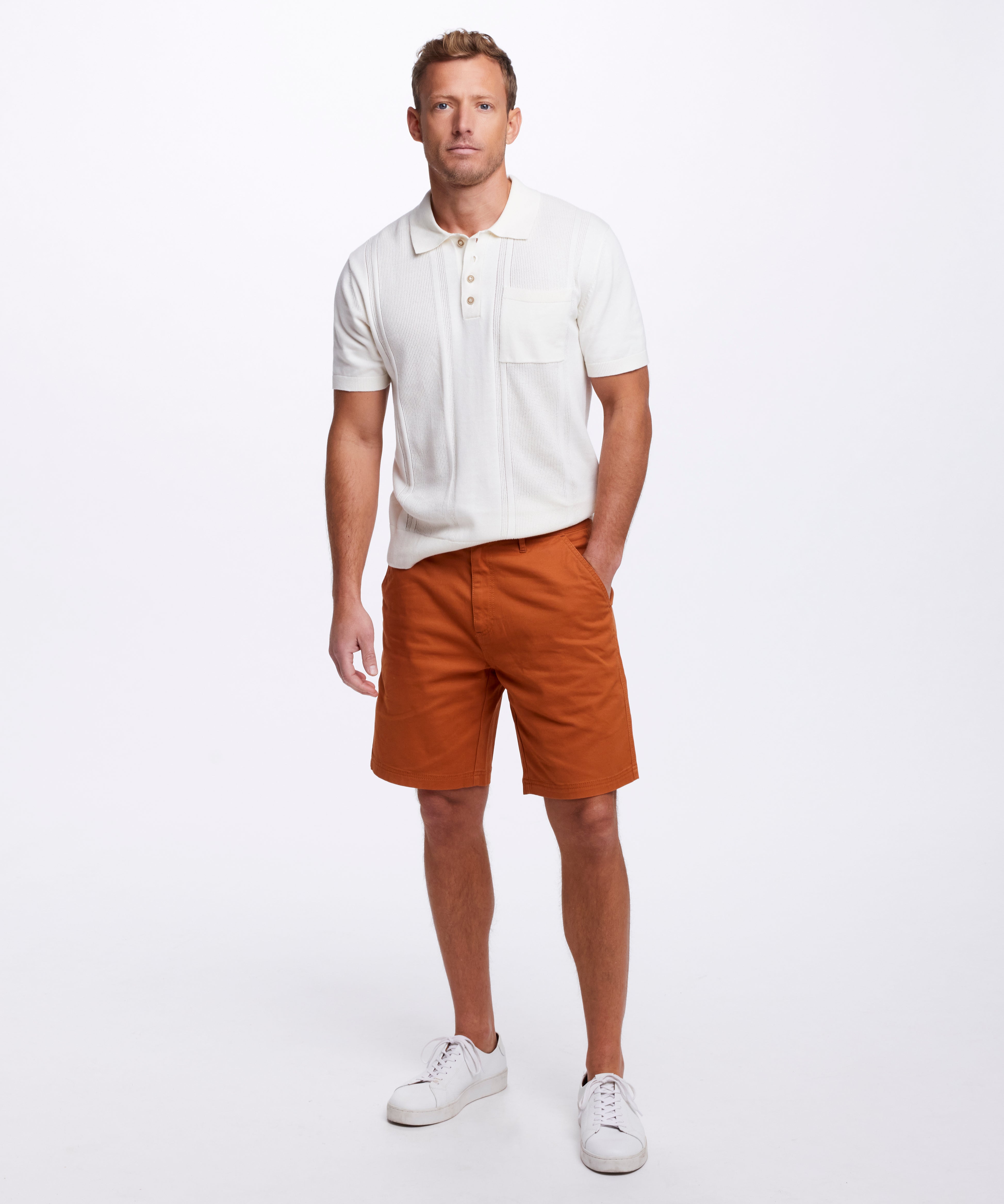 Short Sleeve Polo Sweater In Ecru worn with orange shorts, showcasing a casual yet polished look.