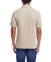 Back view of a man wearing a Waffle Polo In Antique White showcasing its classic fit and short sleeves.