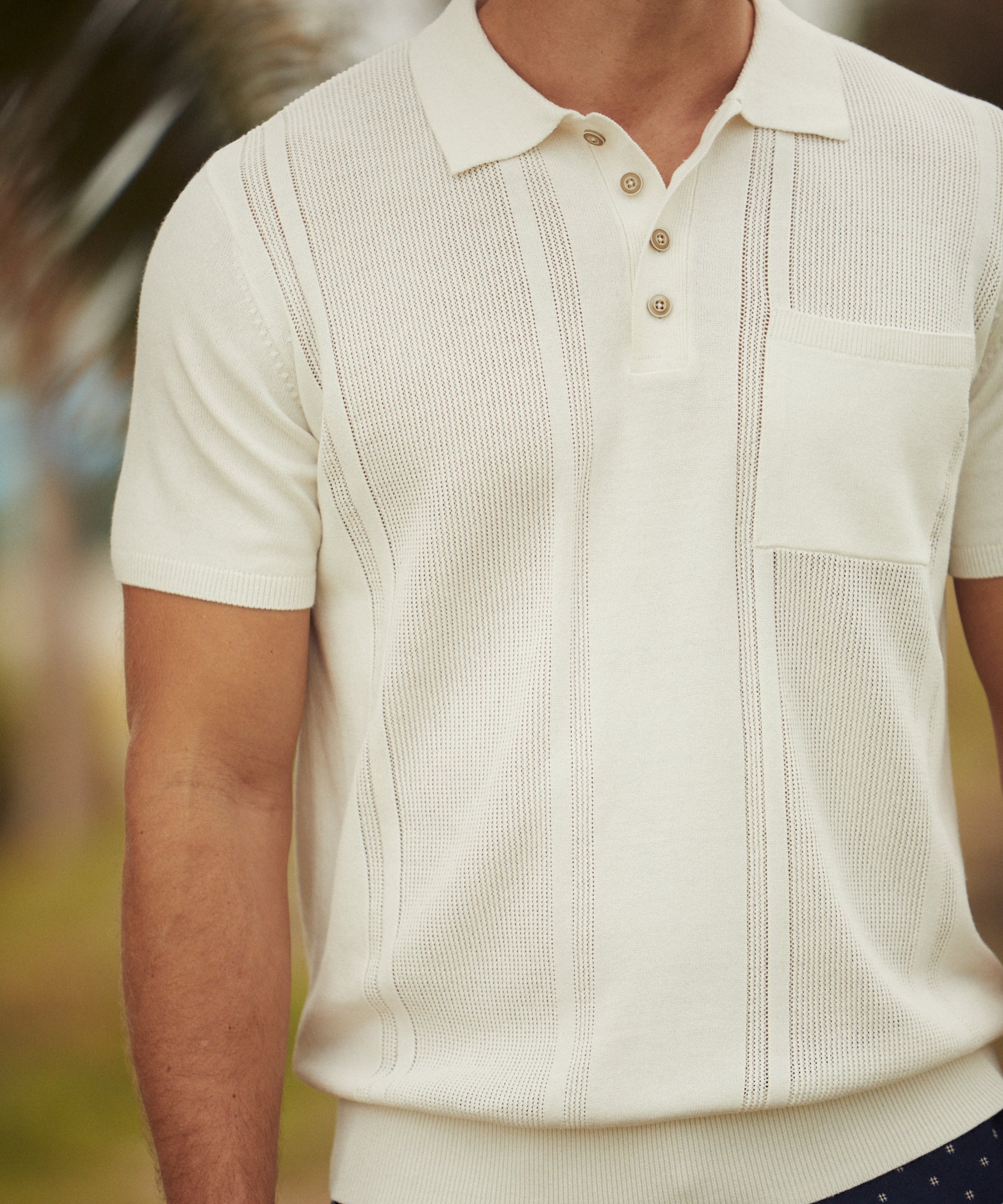 Short Sleeve Polo Sweater In Ecru worn by man outdoors, combining comfort and style with a casual fit.