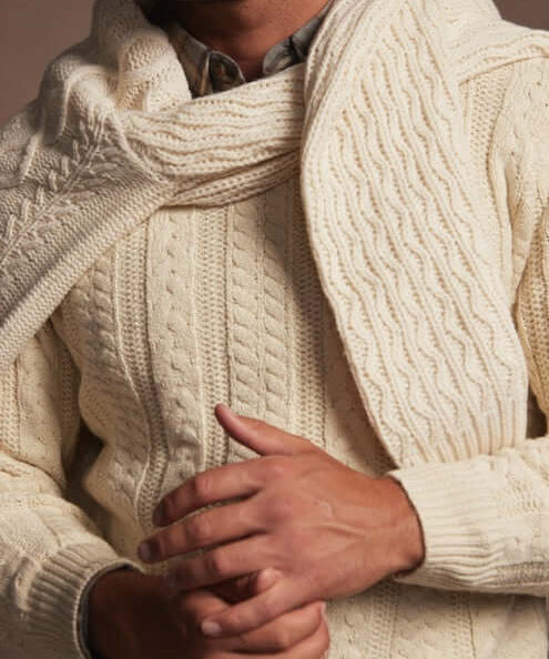 Model wearing an allover cable knit sweater in Whitecap, perfect for cooler weather and everyday style.