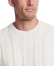 Close-up of a man wearing an allover cable knit crew sweater in white, showcasing its classic design and texture.
