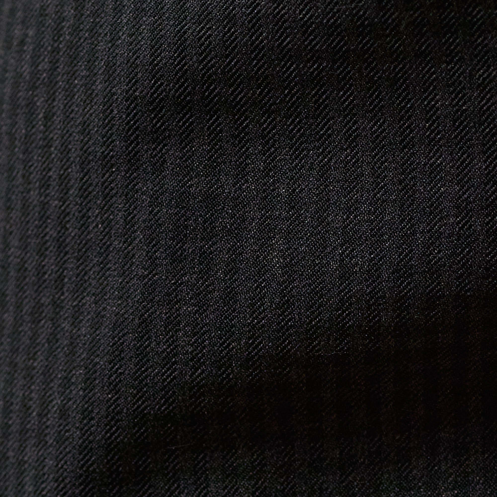 Check Pants in Black/Charcoal fabric close-up showcasing subtle checkered pattern texture.