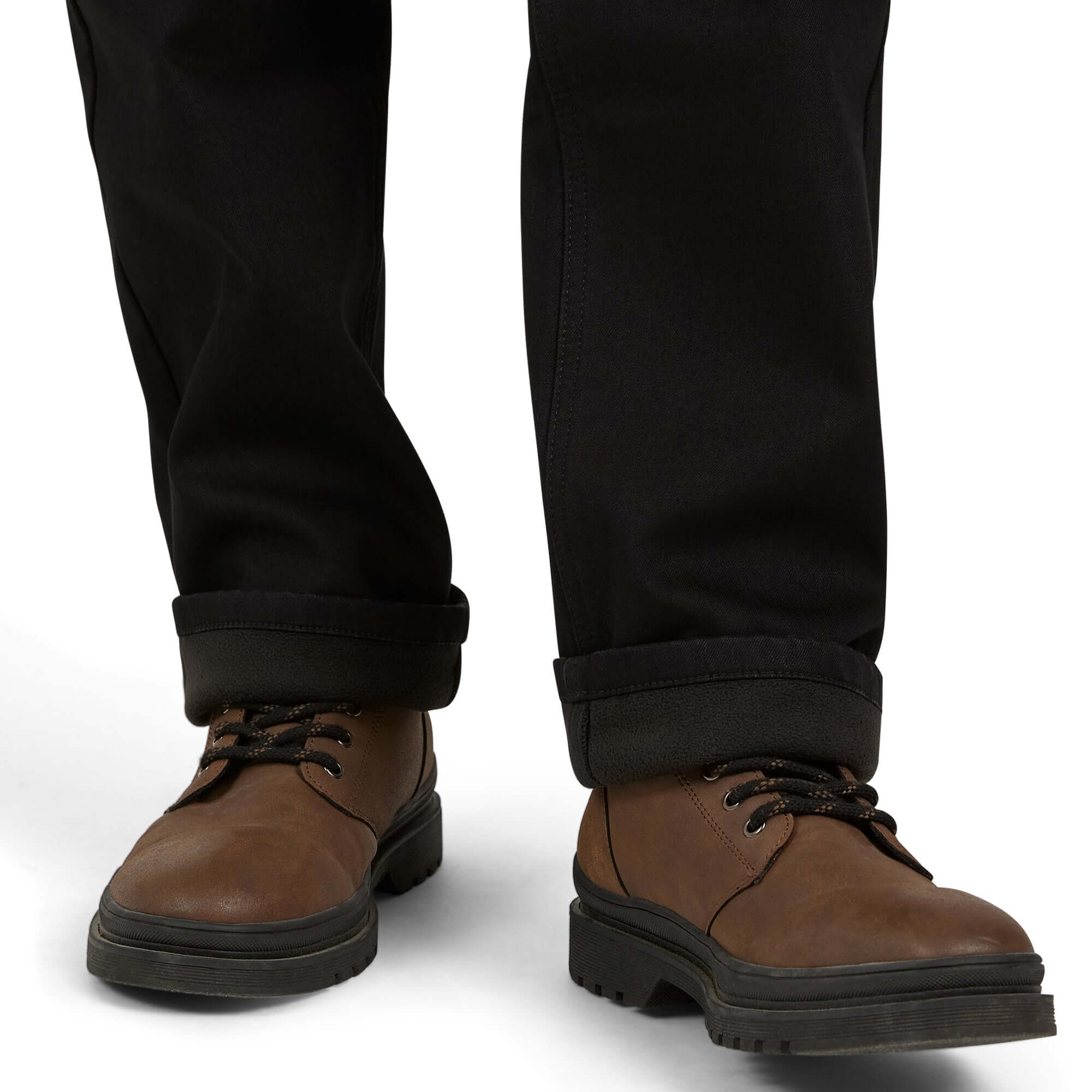 A close-up of brown shoes paired with black fleece-lined jeans, showcasing comfort and style for chilly days.