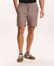 Chambray Stripe Drawstring Short in Brown Stripe modeled by a man wearing side pockets and a drawstring waistband.