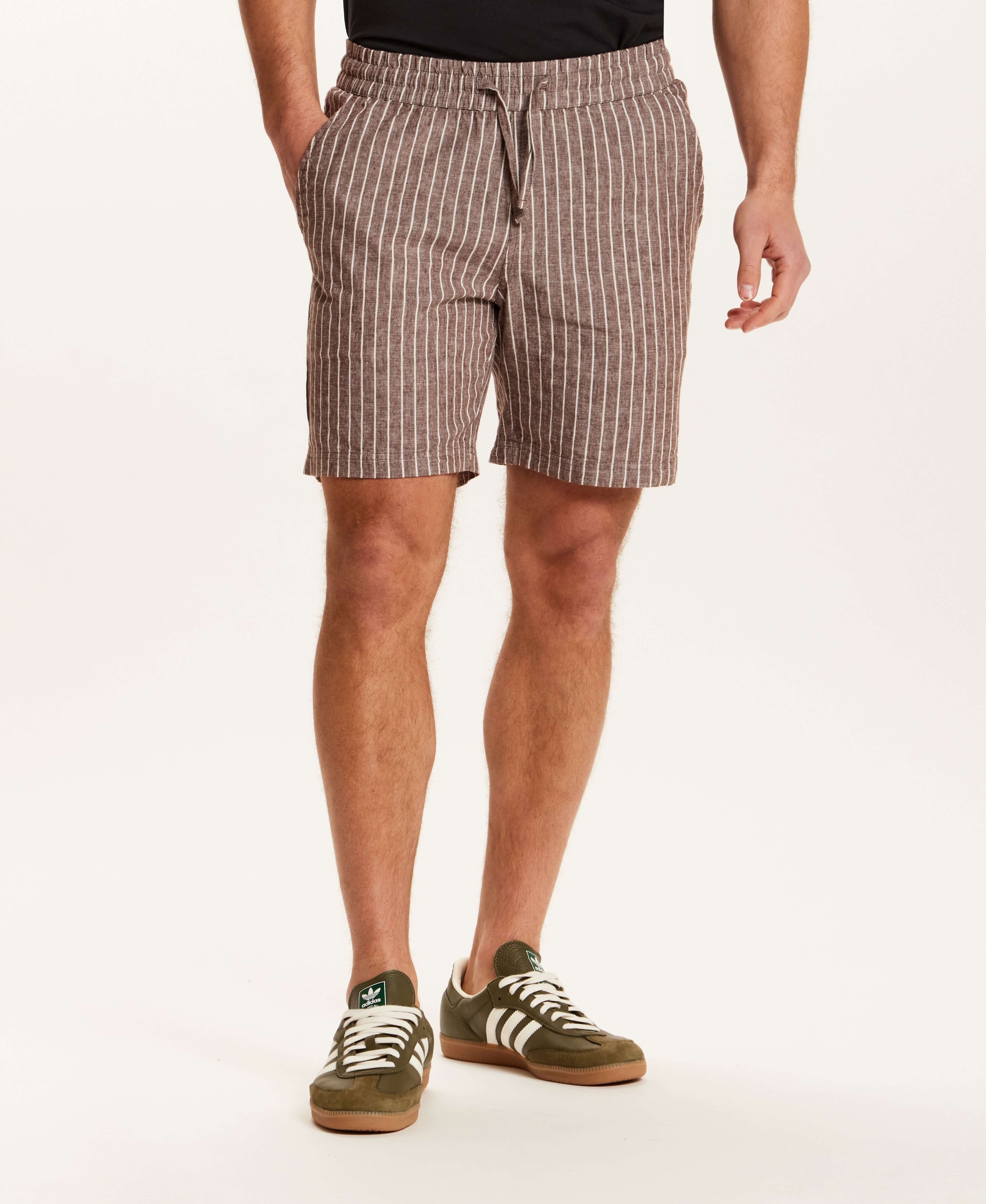 Chambray Stripe Drawstring Short in Brown Stripe modeled by a man wearing side pockets and a drawstring waistband.