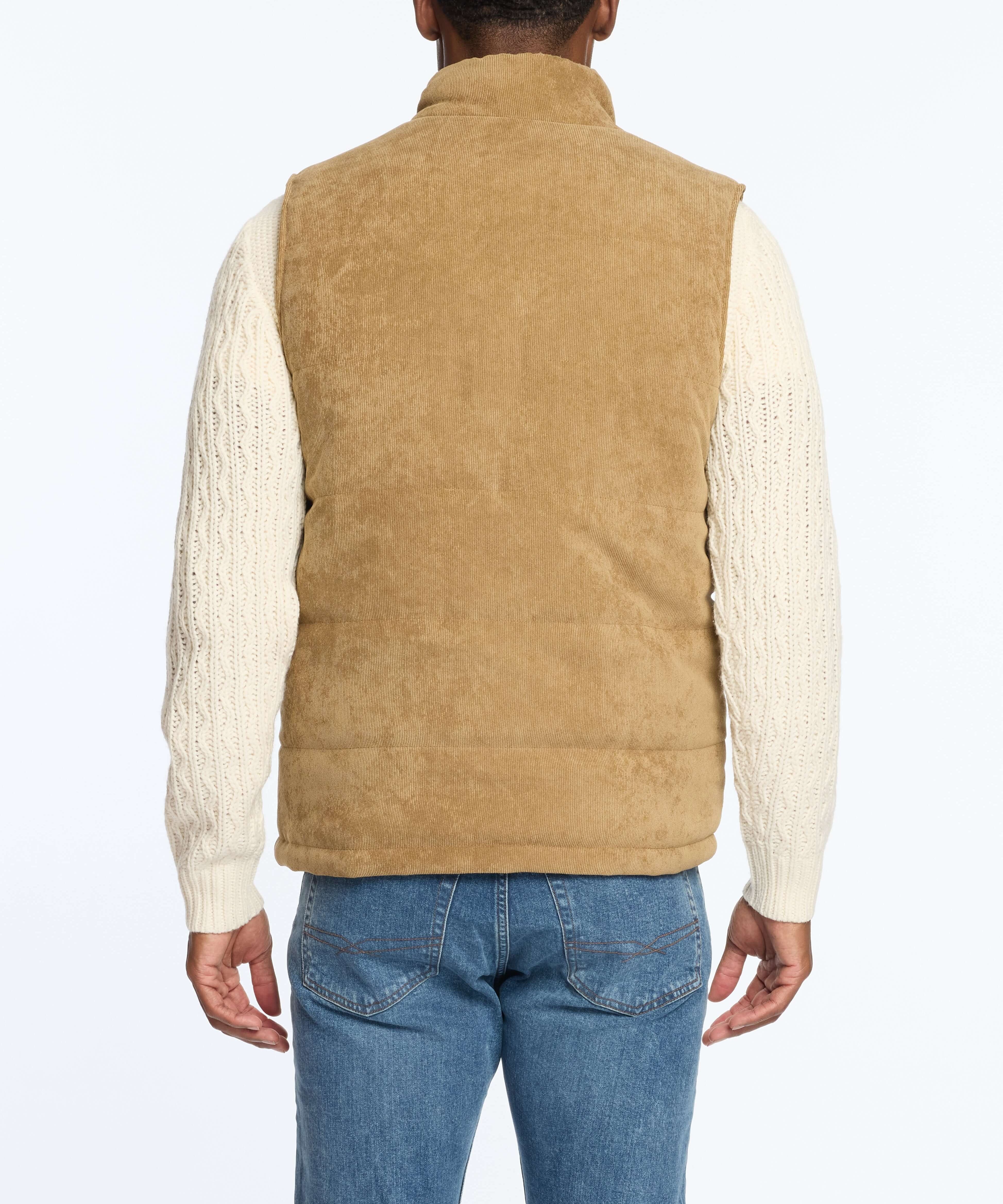 Back view of a man wearing a corded puffer vest in kangaroo color, featuring sherpa lining and side pockets.
