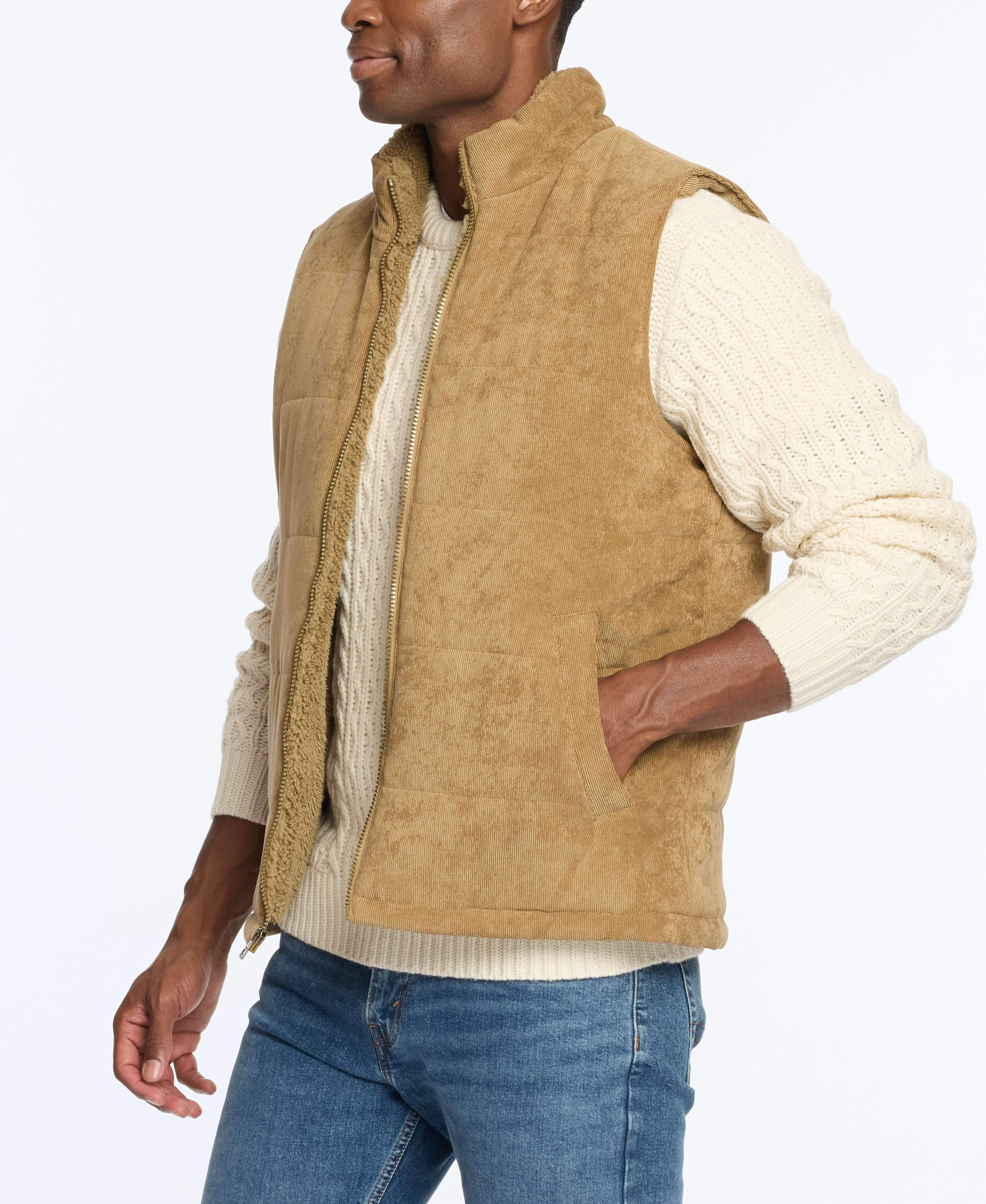 Man wearing a corded puffer vest in kangaroo color, layered over a cream sweater, showcasing a stylish winter look.