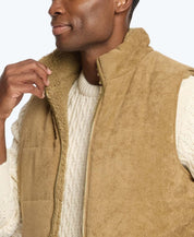 Man wearing a cozy corded puffer vest lined with shearling, perfect for layering on chilly days.