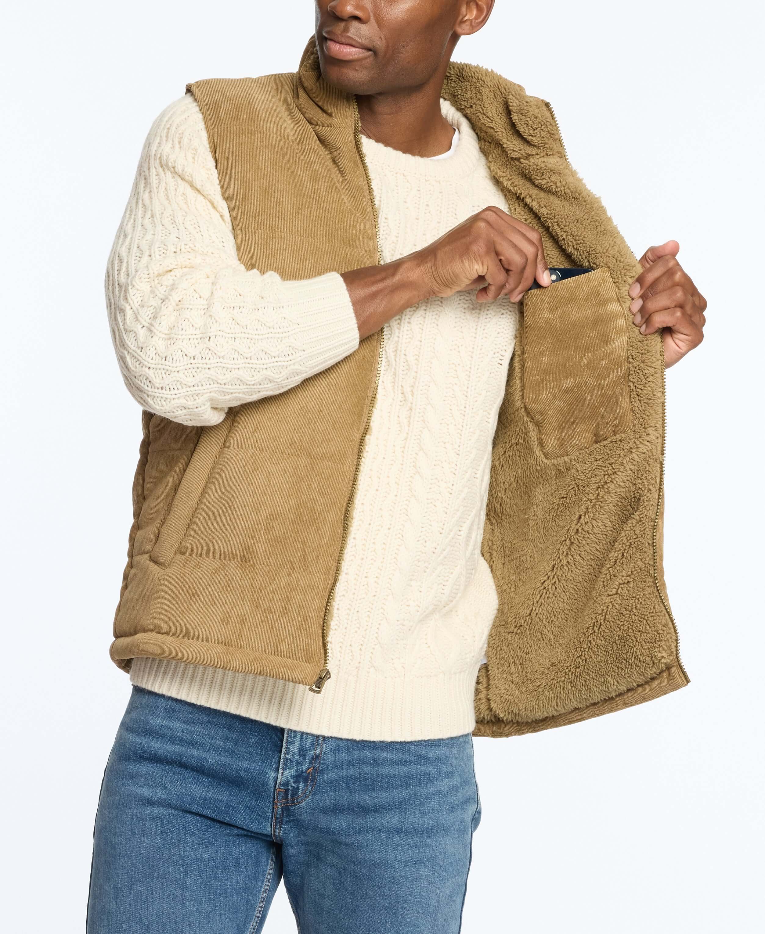 Model wearing a corded puffer vest with shearling lining, showcasing zip front and side pockets.