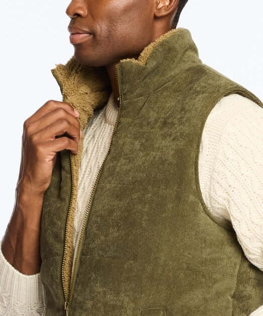 Man wearing a corded puffer vest in olive green with shearling lining, perfect for chilly days and stylish layering.