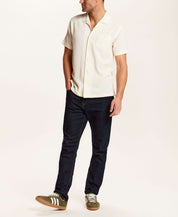 Model wearing Crinkle Texture Camp Collar Shirt in Cream with dark jeans and sneakers.