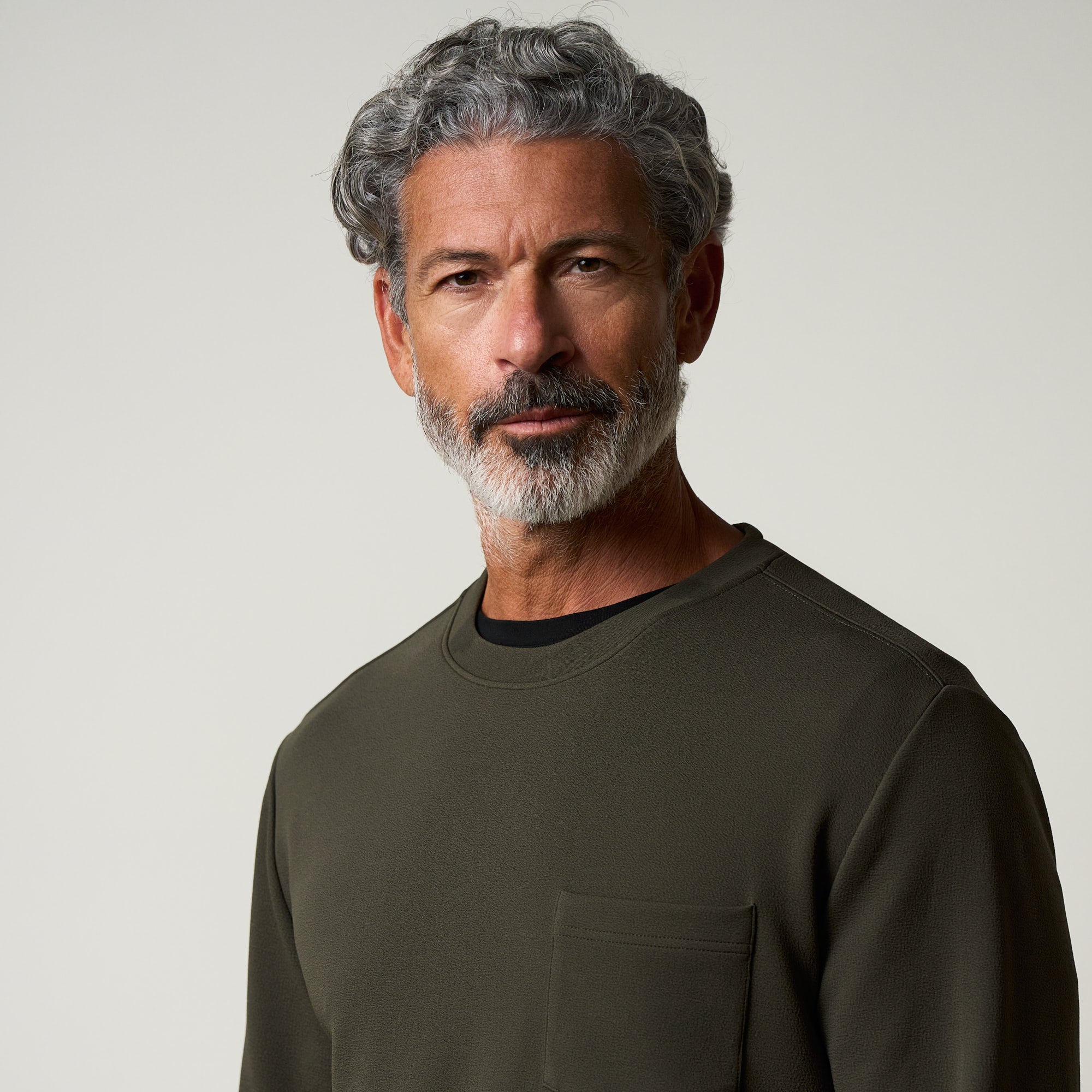 Crinkle Scuba Crew Neck in Olive worn by a model with gray hair and beard, showcasing its textured fabric.