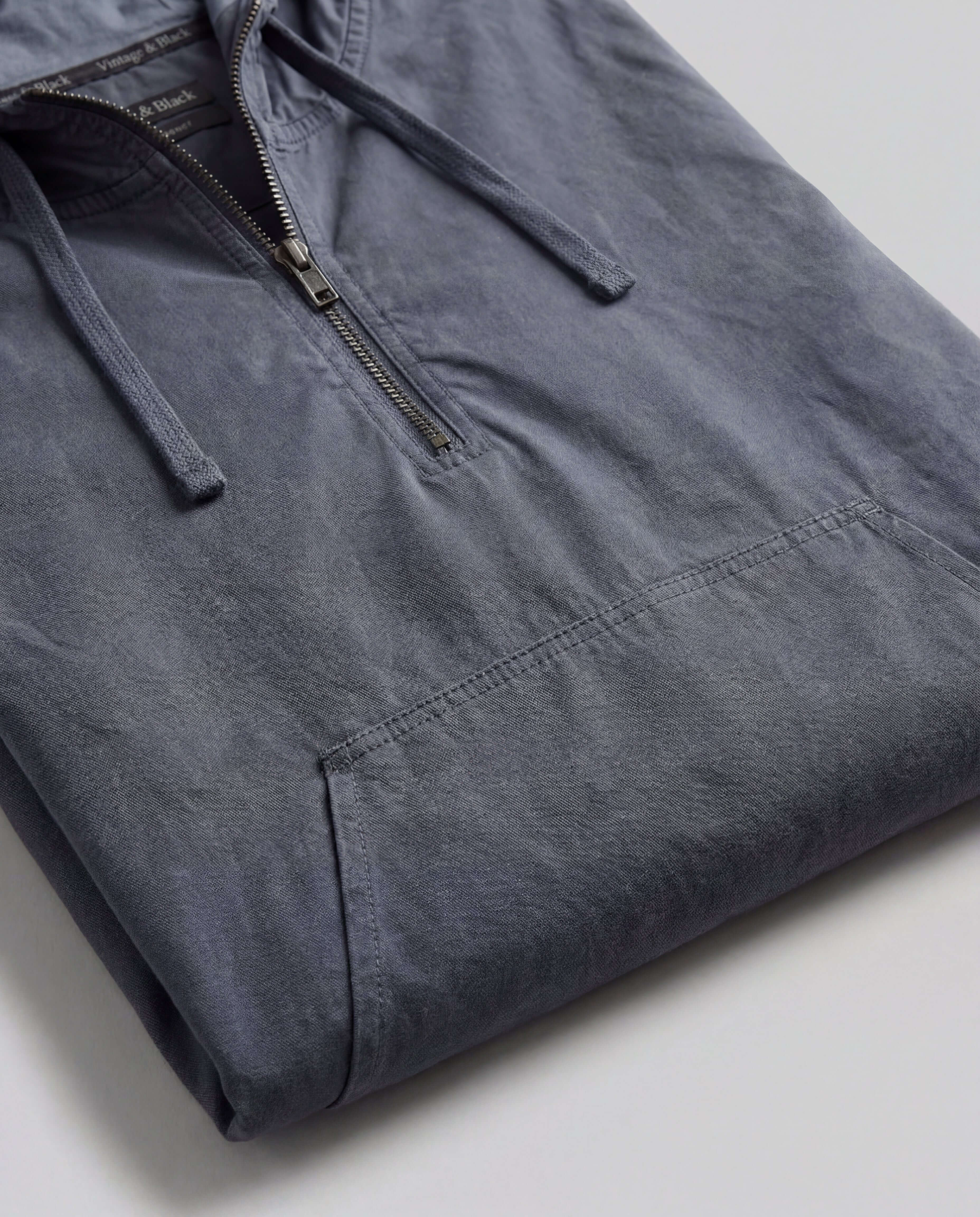 Distressed Poplin Hooded Pullover in Indigo laid flat, showcasing its half-zip front and front pouch pocket.