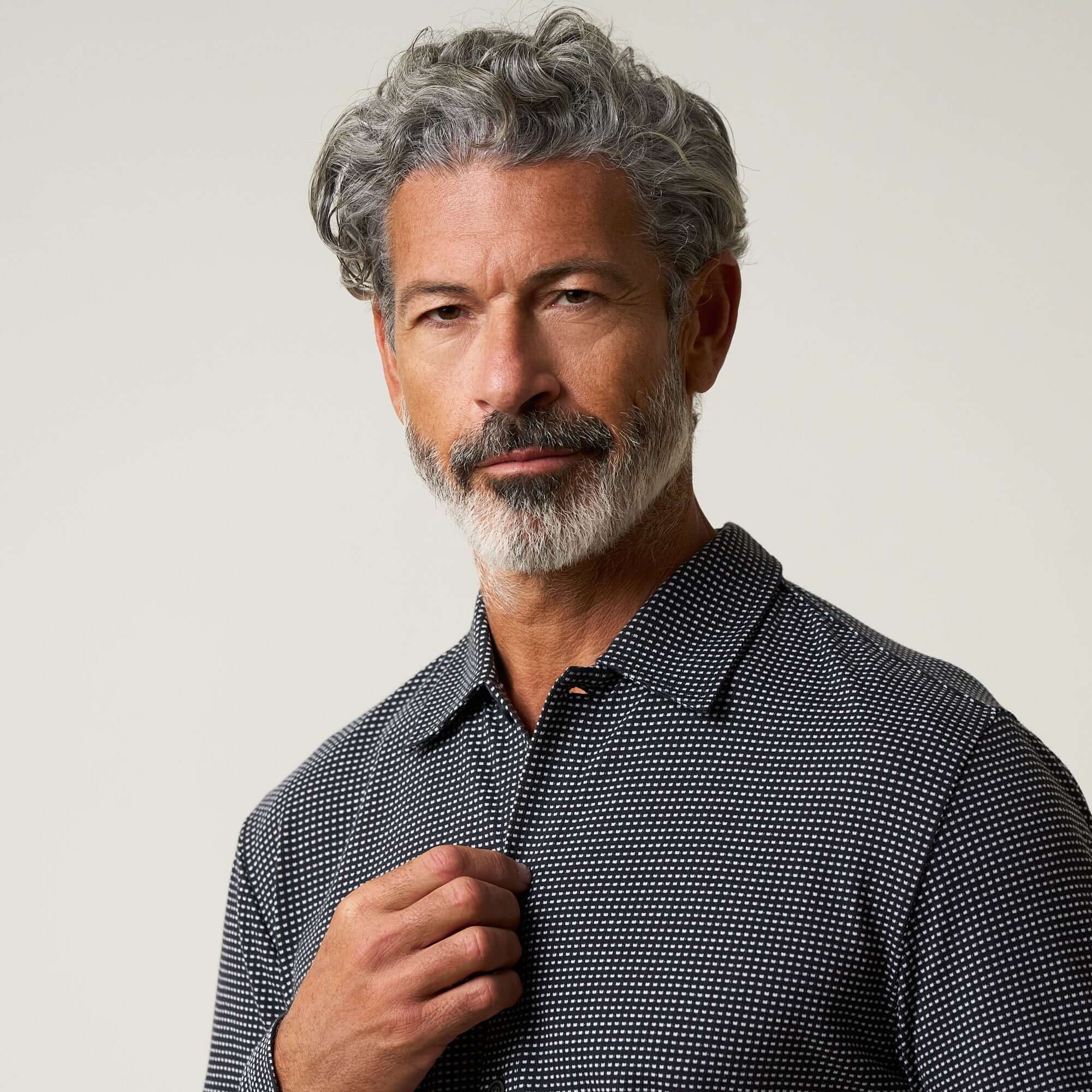 Dobby Button Down Shirt in Black worn by a man with gray hair, showcasing its versatile style and subtle texture.