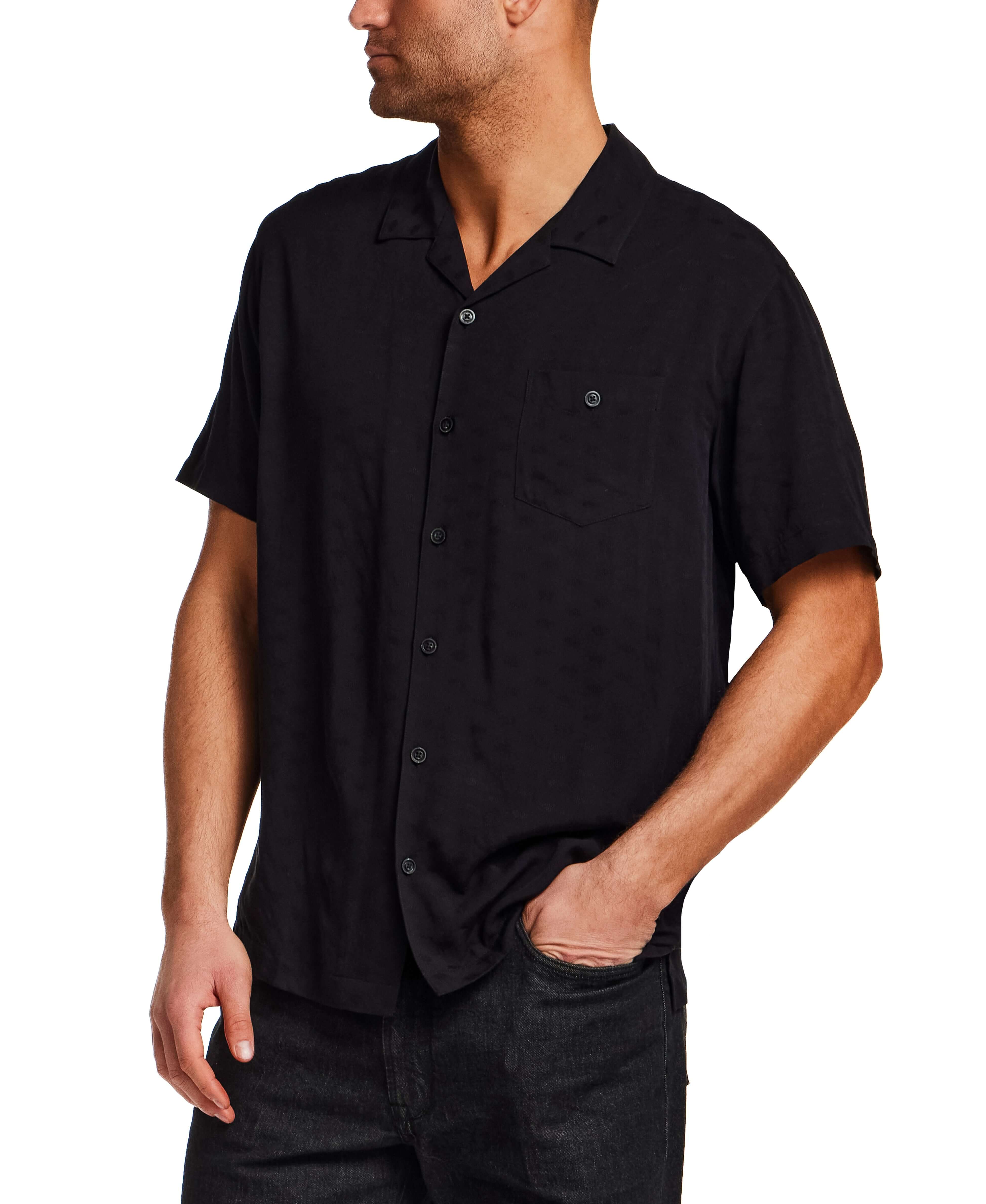 The Dobby Camp Collar Shirt in Black worn by a model with a relaxed fit and camp collar design.